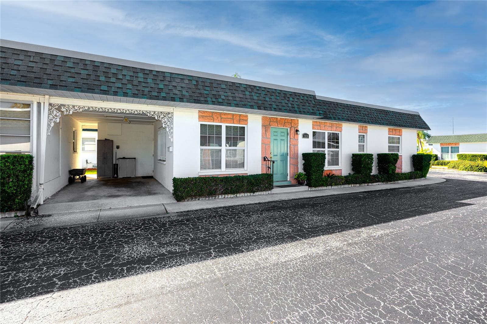 Front view showing covered carport with entrance to front and back patio/yard area.