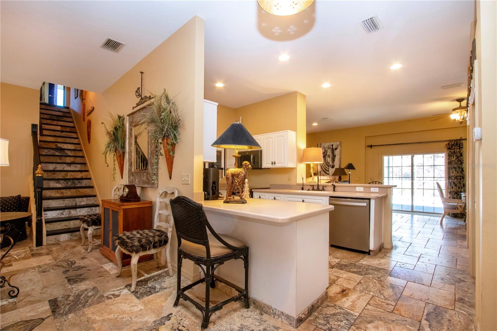view of the kitchen and sliding doors that lead to the pool from the dining room