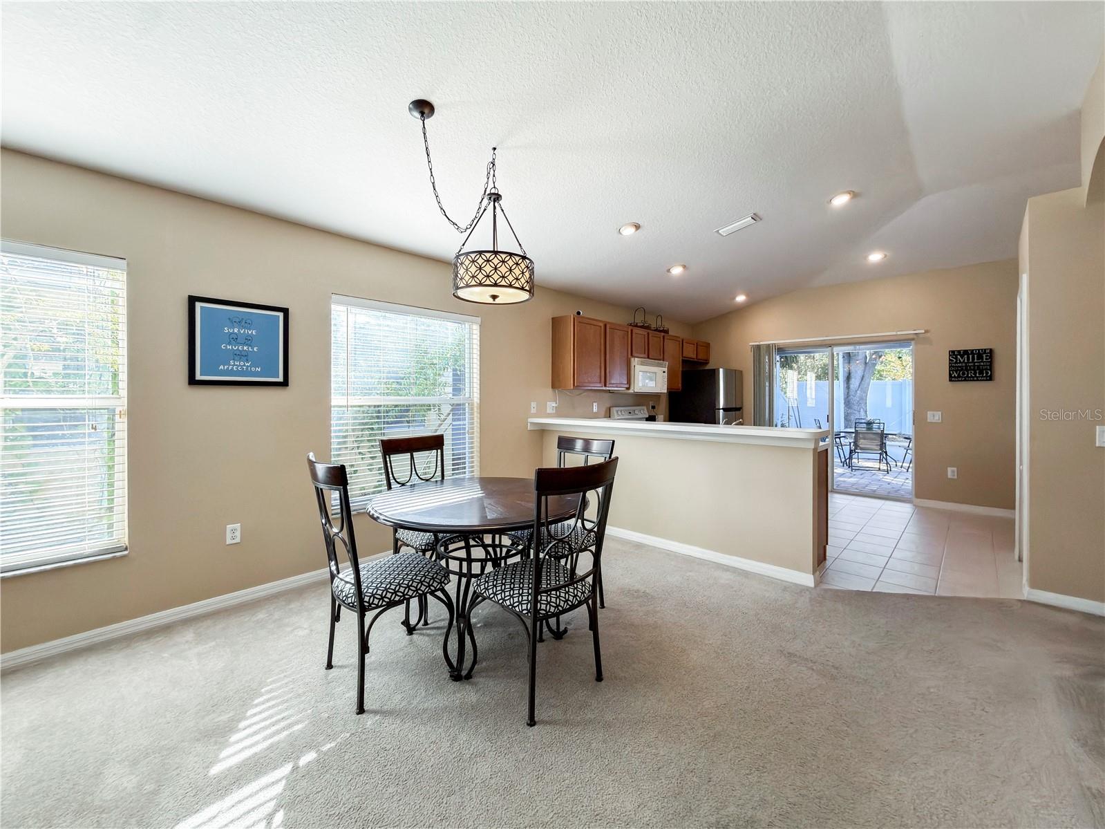 Dining area with tons of natural light, breakfast bar overlooks kitchen