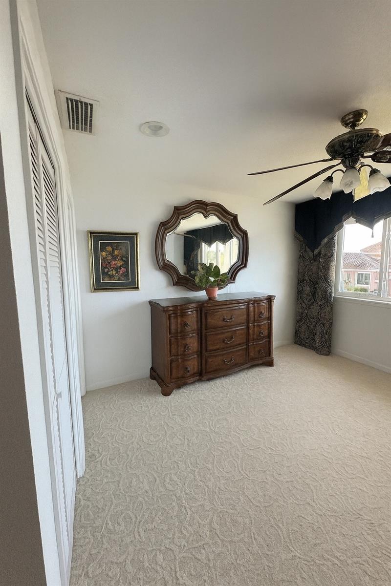 Spacious master suite featuring elegant furnishings, abundant natural light, and serene water views throughout