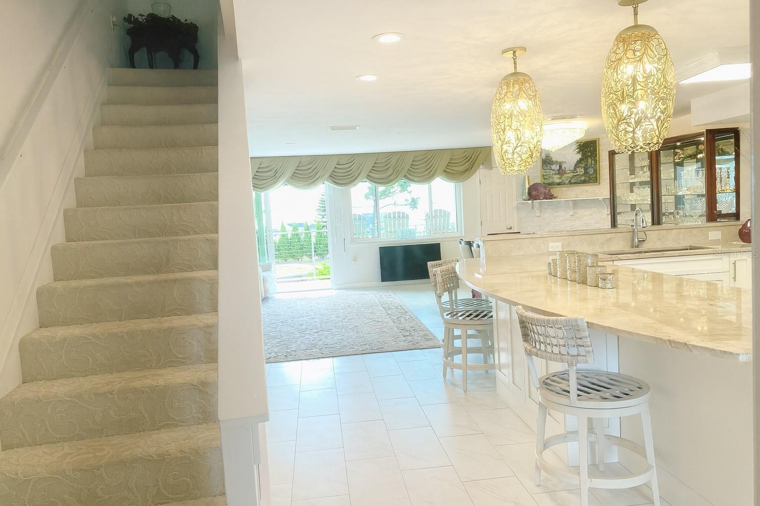 ChatGPT said:Bright open layout with elegant kitchen, stylish lighting, and water views.