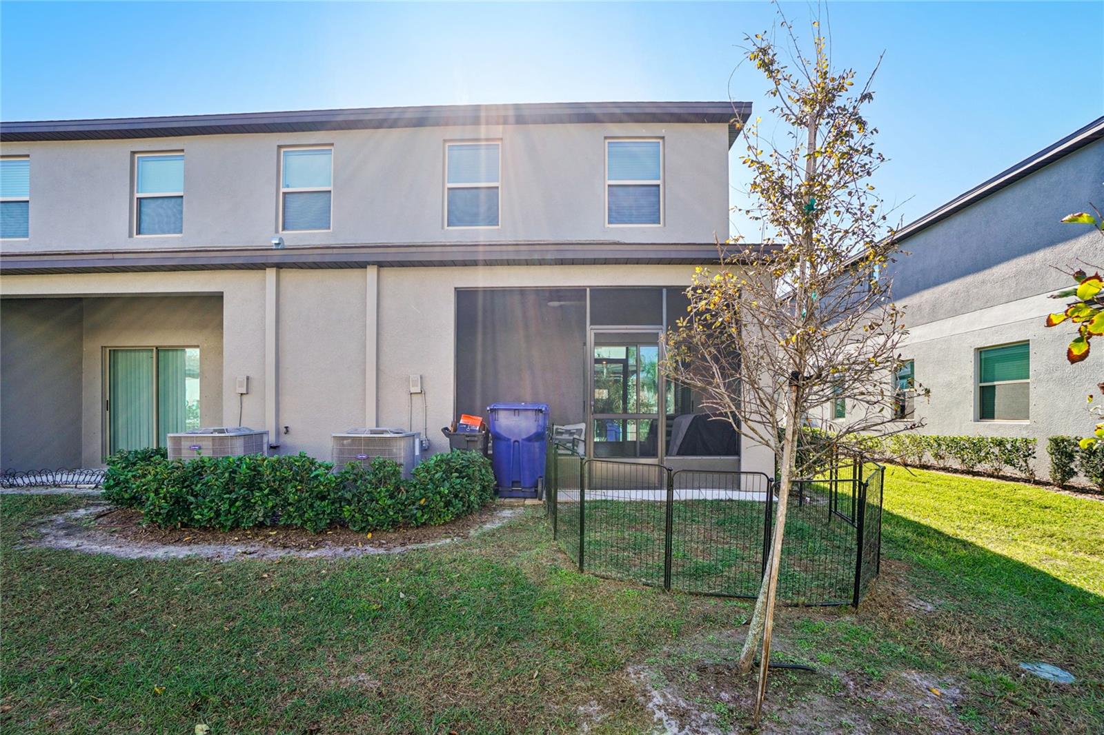 Rear Exterior – Angle 1 – Exterior view of the home showcasing the screened-in patio and backyard space with maintained landscaping.