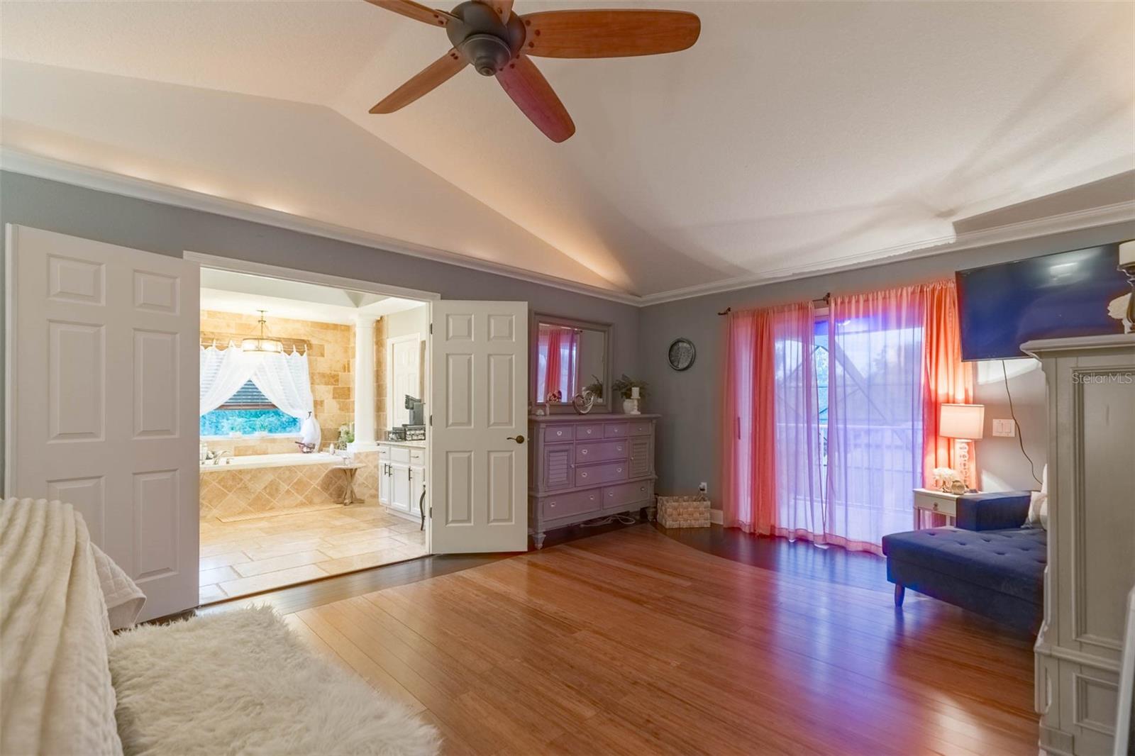 Primary bedroom with extended area for WFH, larger furniture, high ceilings.