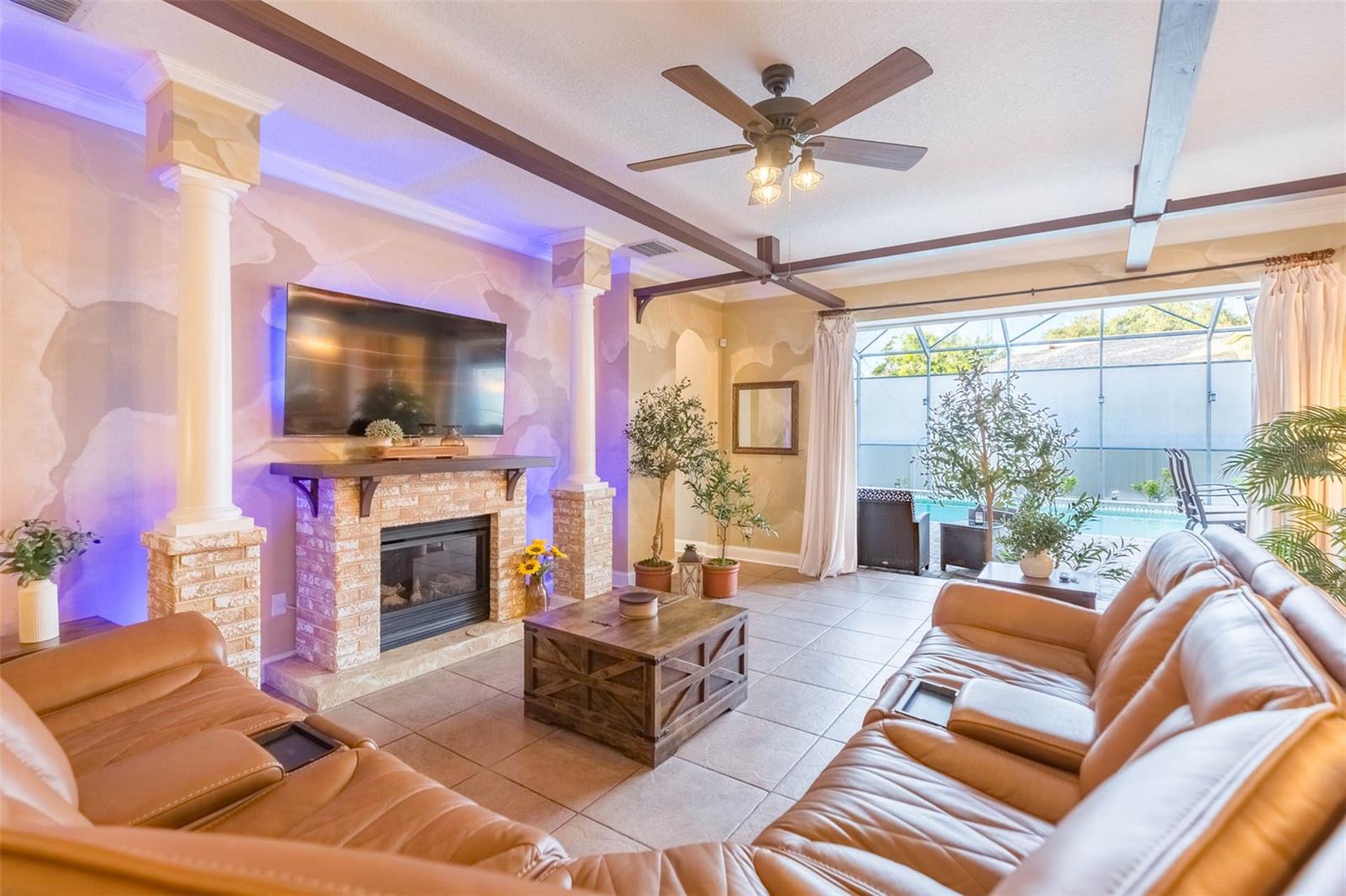 Professionally decorated great room including fireplace, formal columns and wall painting