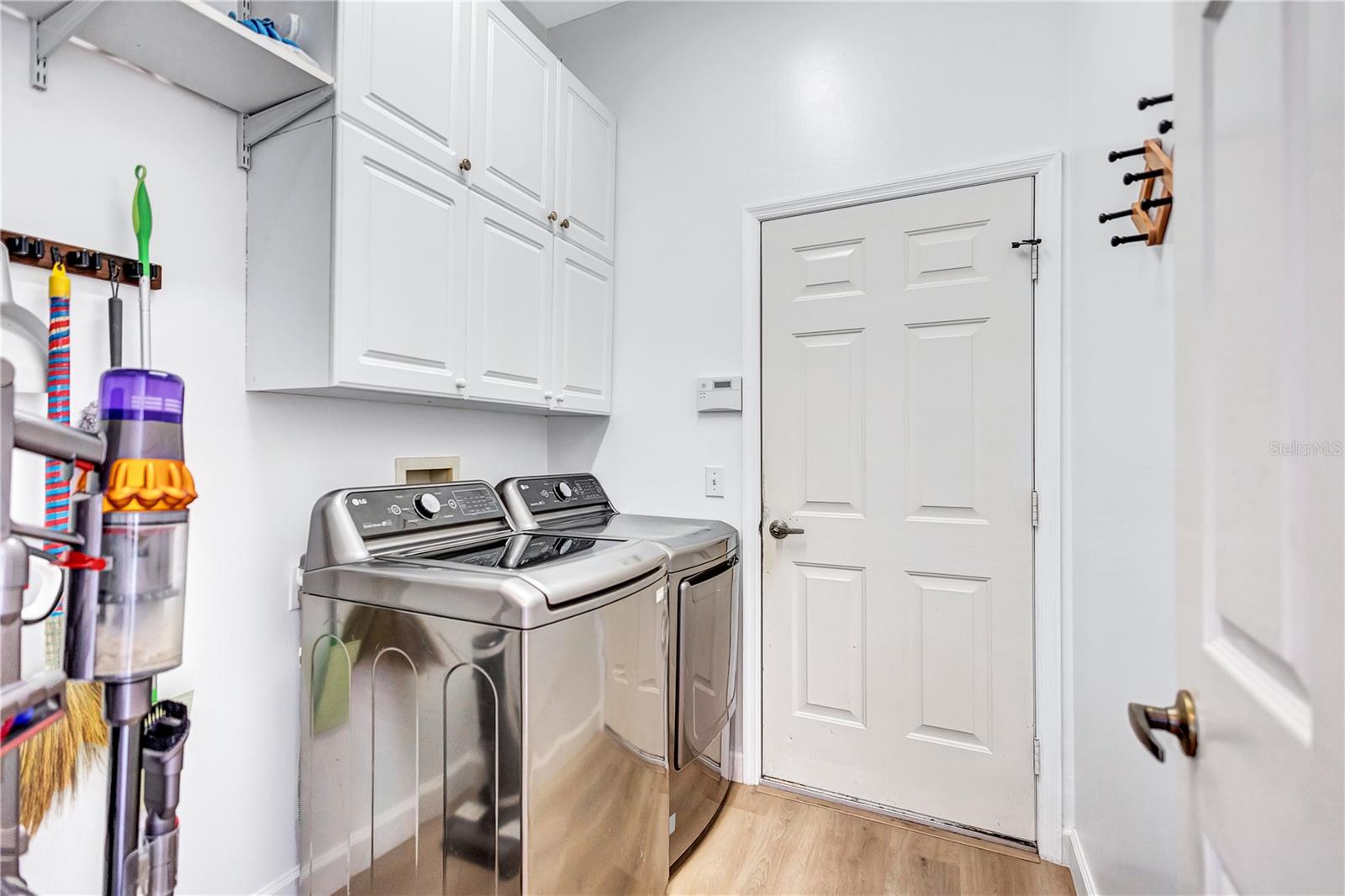 Laundry Room with Cabinets, Shelving and garage entry door
