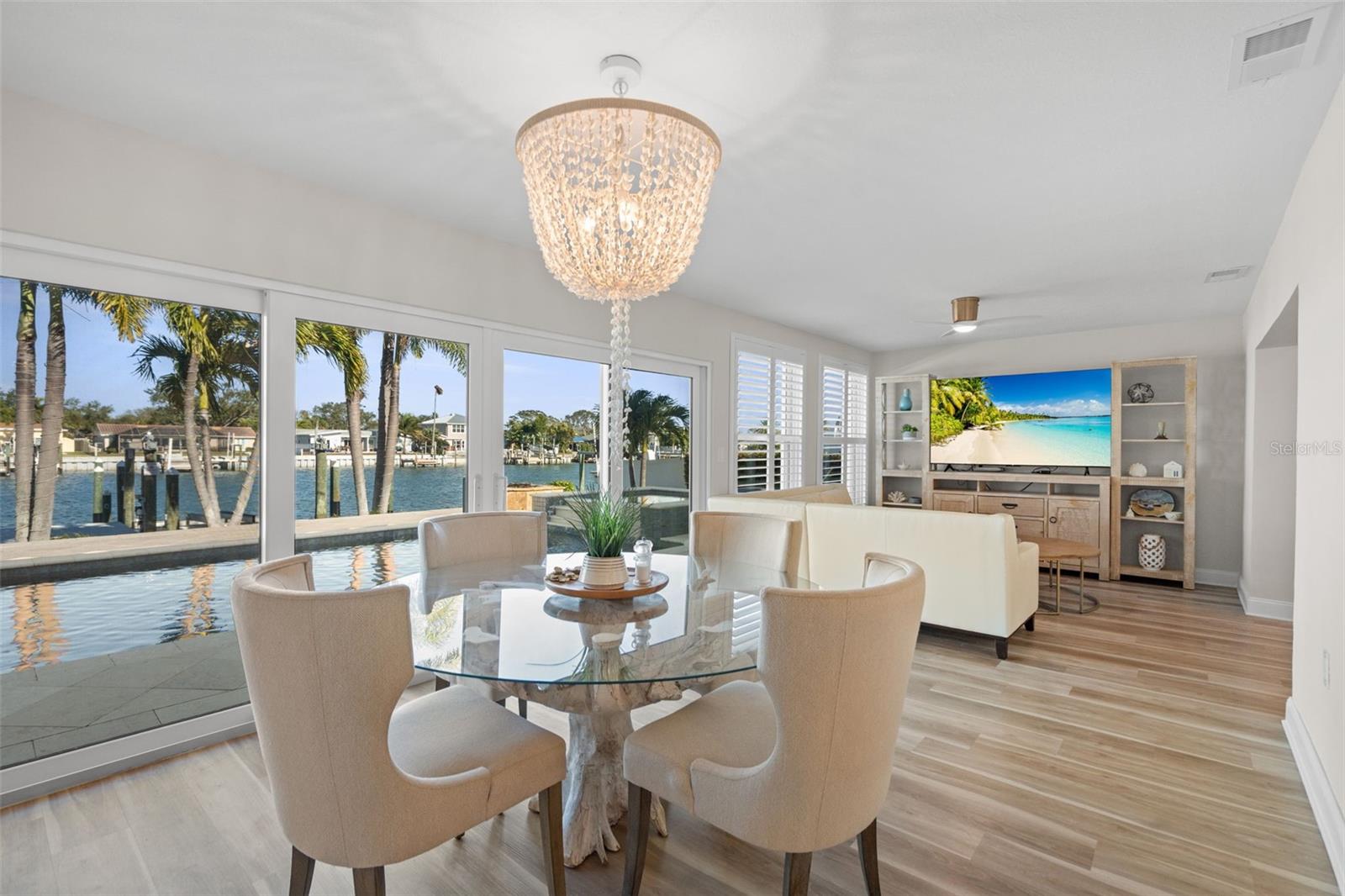 Dining area framed by sliding glass doors and serene water views.