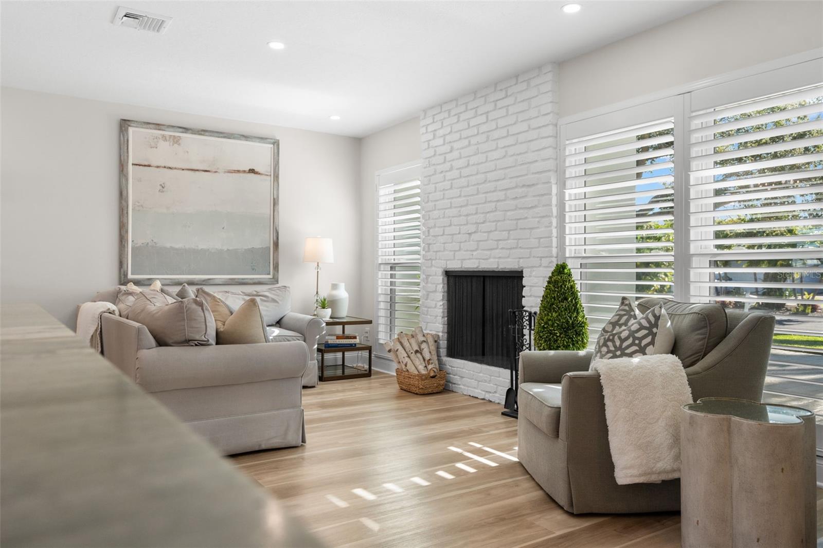 Bright living room featuring an updated fireplace and abundant natural light.