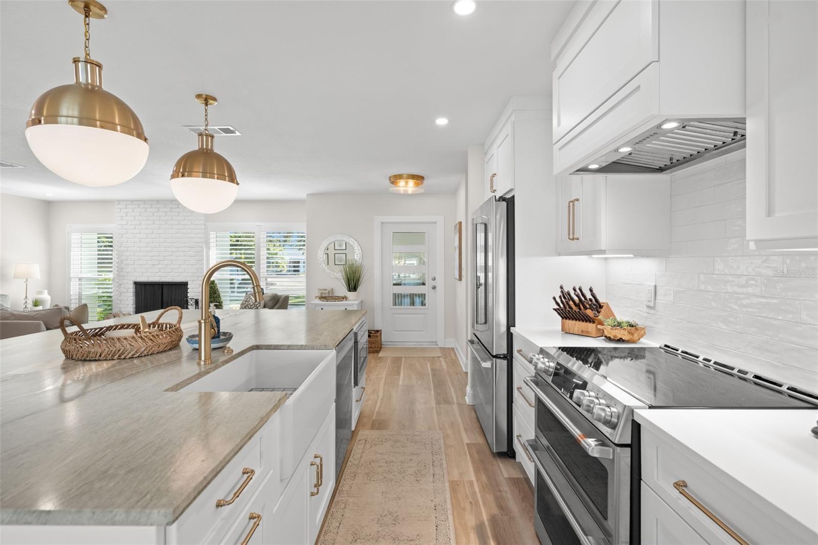 Designer kitchen with oversized island, quartz counters, and brass accents.