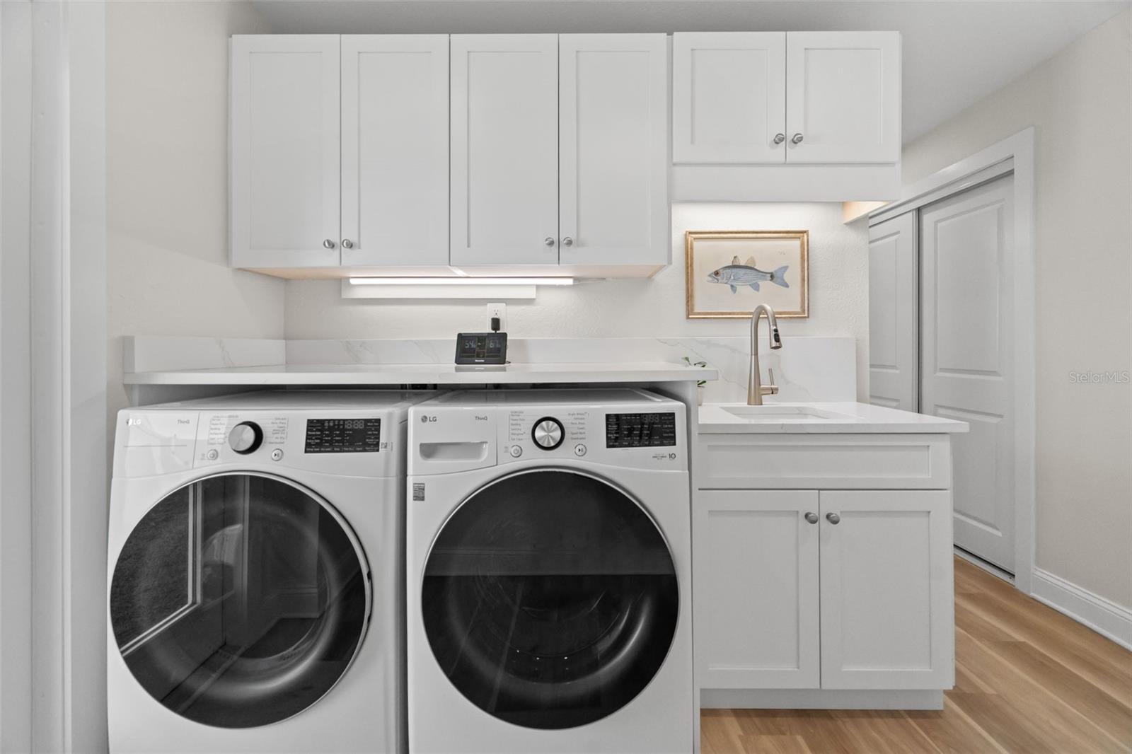 Dedicated laundry room with storage cabinets and exterior access.