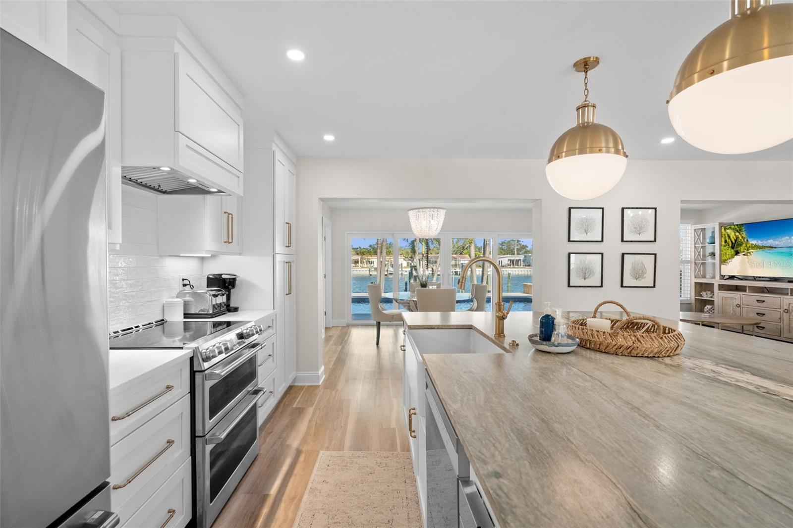 Designer kitchen with oversized island, quartz counters, and brass accents.