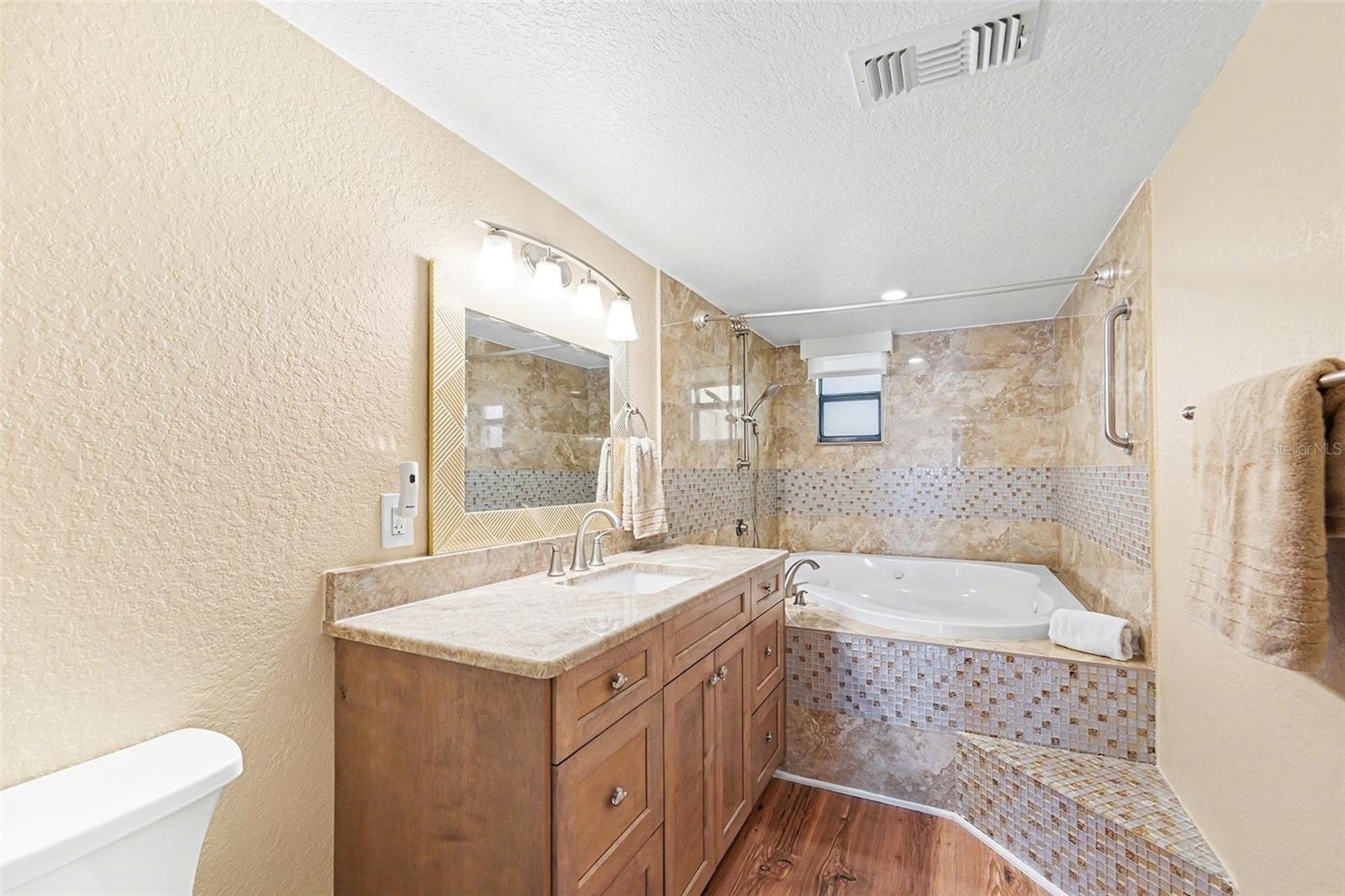 Primary bathroom with jetted tub, new cabinets, and countertop.
