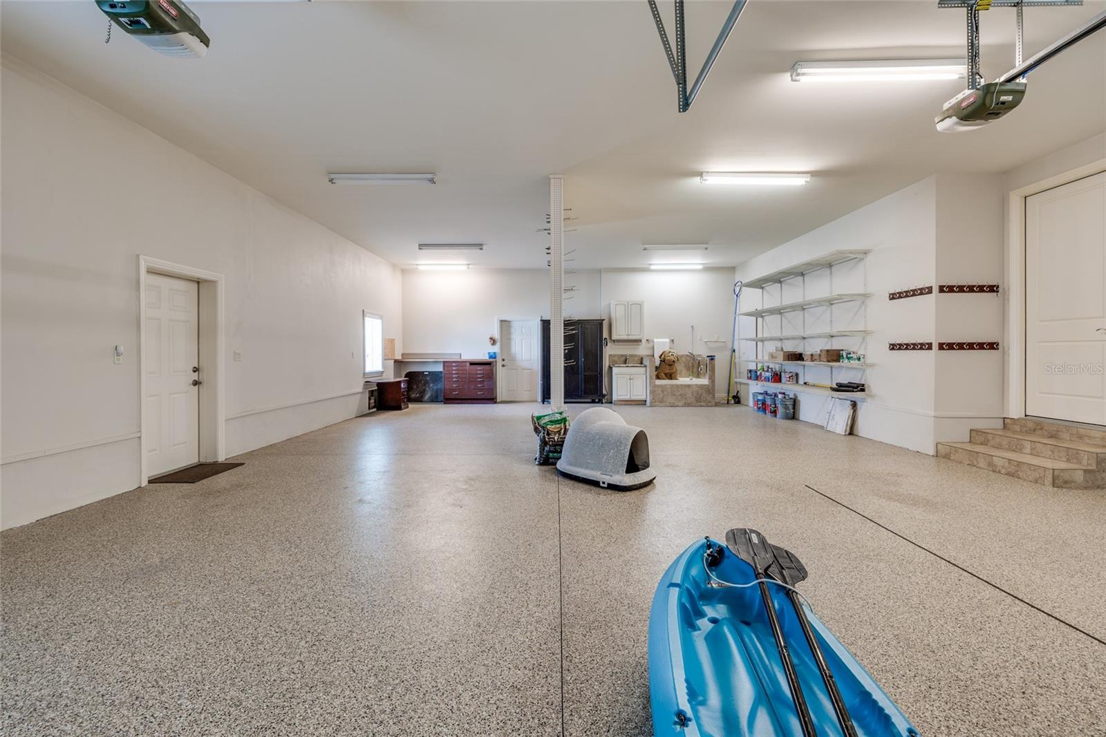 4 Car Tandem Garage with Hurricane Rated Doors and Polyaspartic speckled garage flooring.
