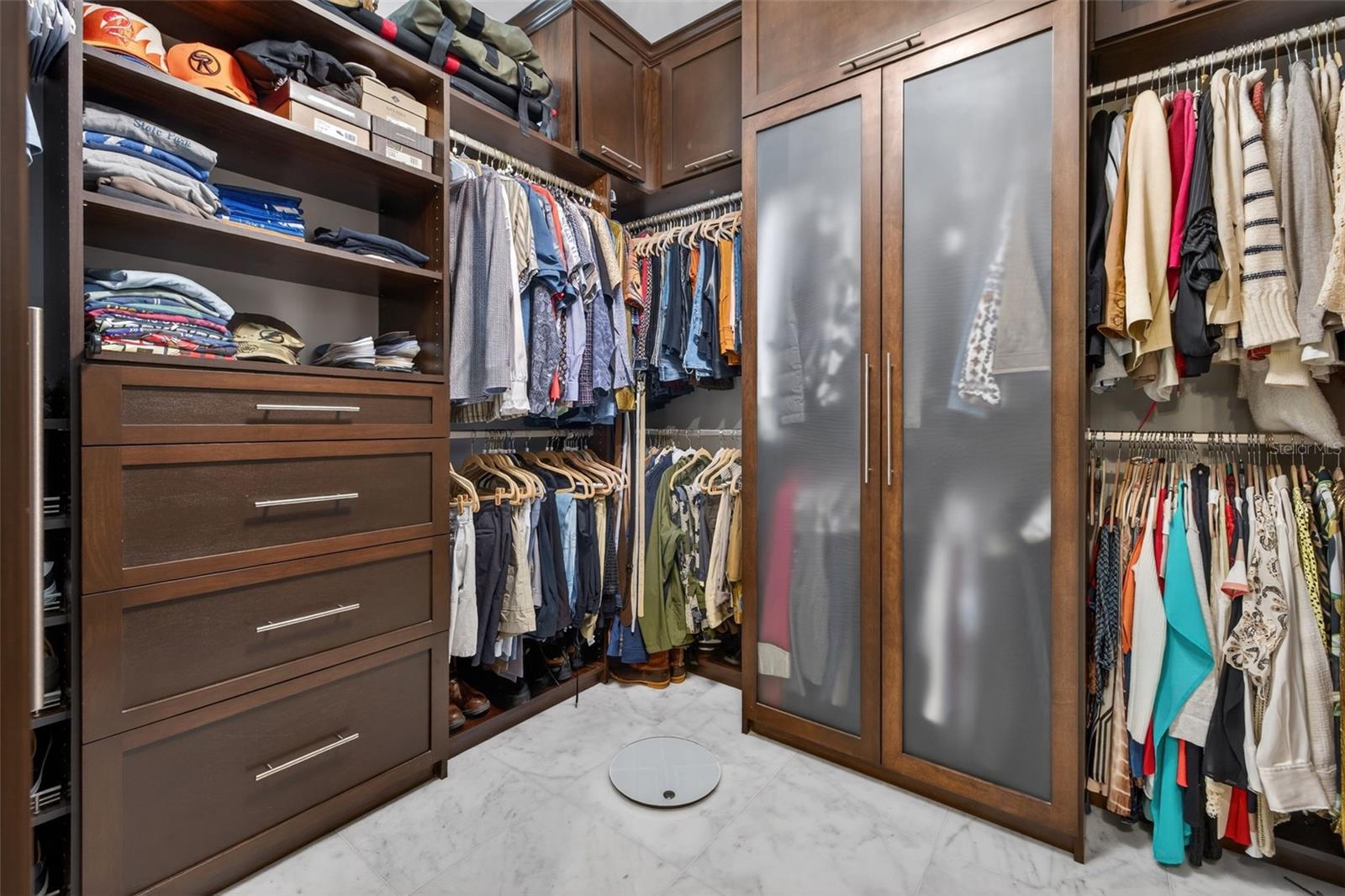 Primary suite walk-in closet featuring generous storage and elegant design.