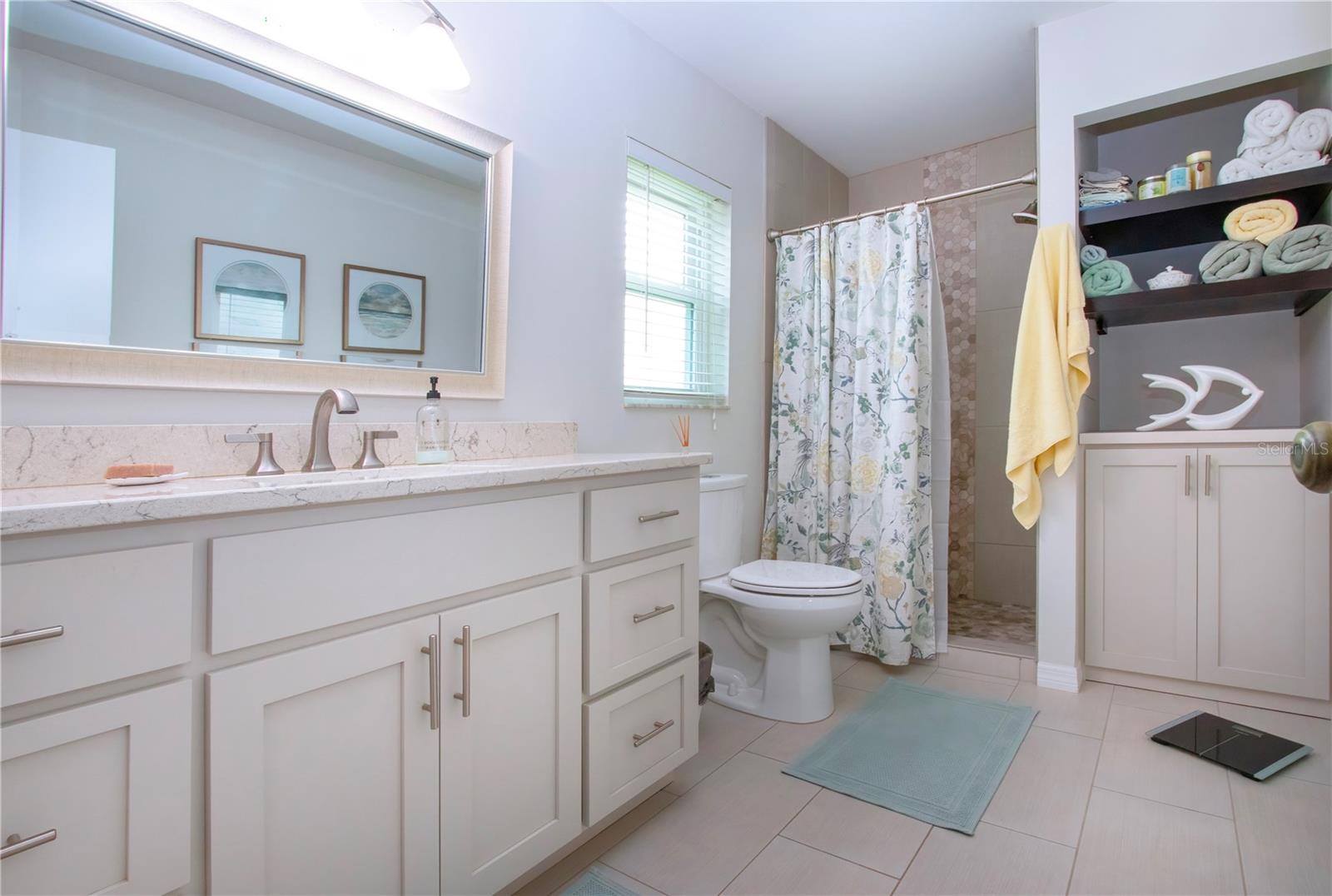 Updated Bathroom w/walk in shower, designer tile, quartz countertop, new flooring