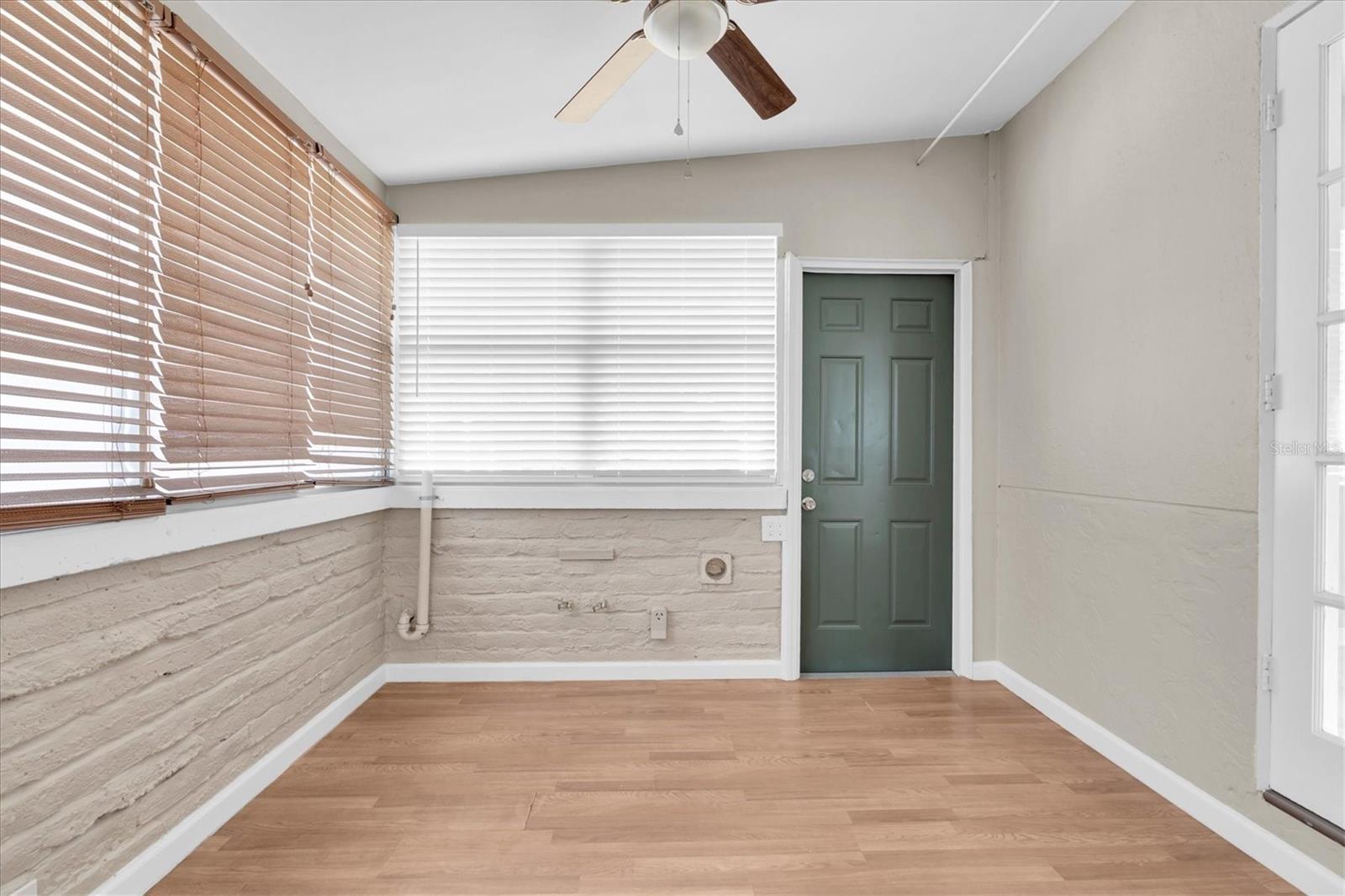 The laundry area is just off the kitchen, next to the door to the backyard.