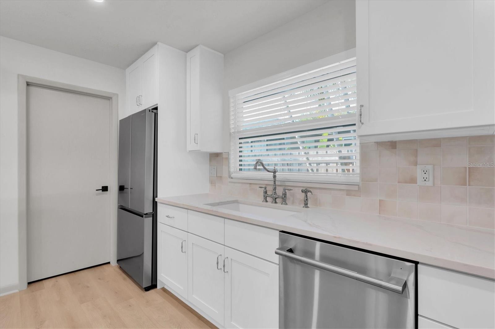 The door by the refrigerator leads to the laundry & pantry space.