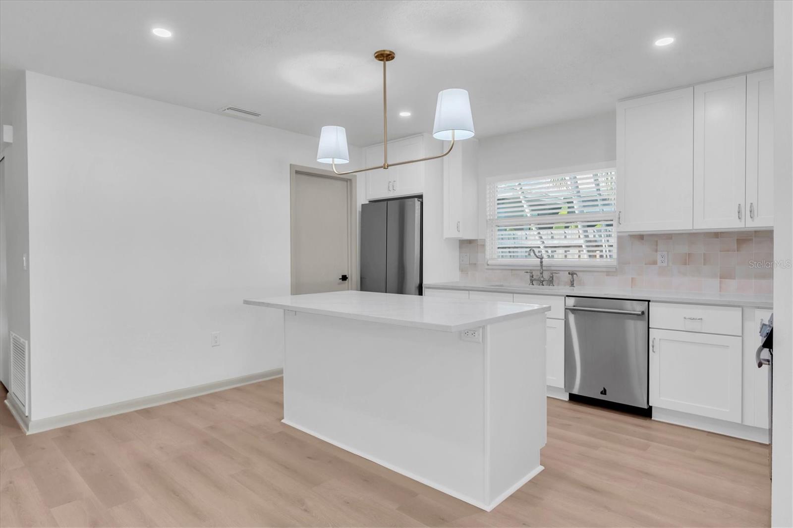 The all new kitchen has a large island with a breakfast bar.