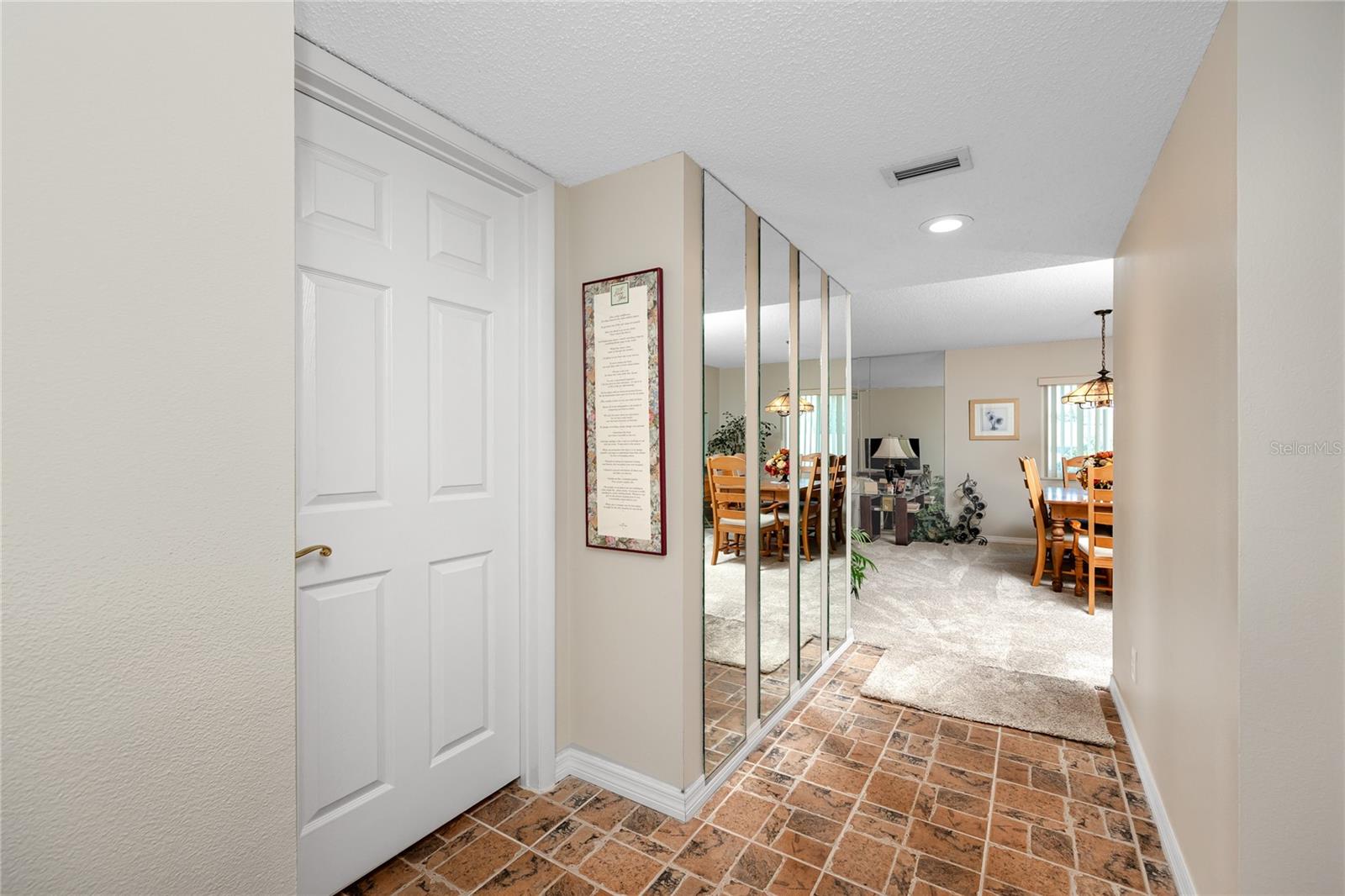 Facing into the living room from the front door. Door to left is primary, hall to right is guest bathroom and bedroom
