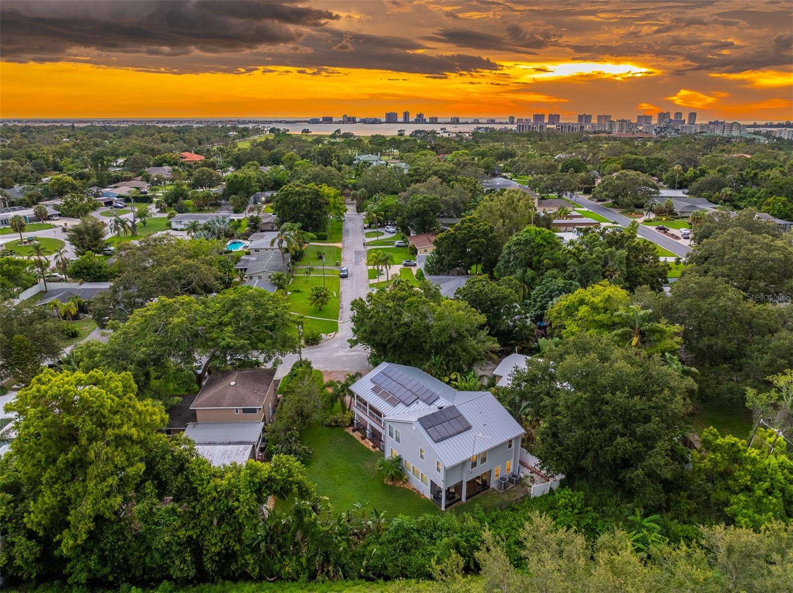Aerial view of the property capturing shimmering water and a breathtaking sunset