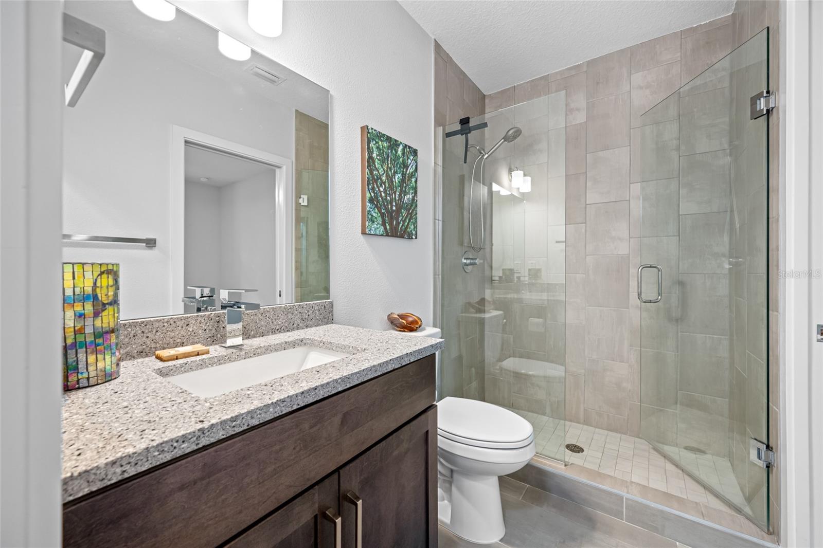 Full bathroom with walk-in shower. First Floor - Bedroom 3 with en-suite full bathroom & walk-in closet.