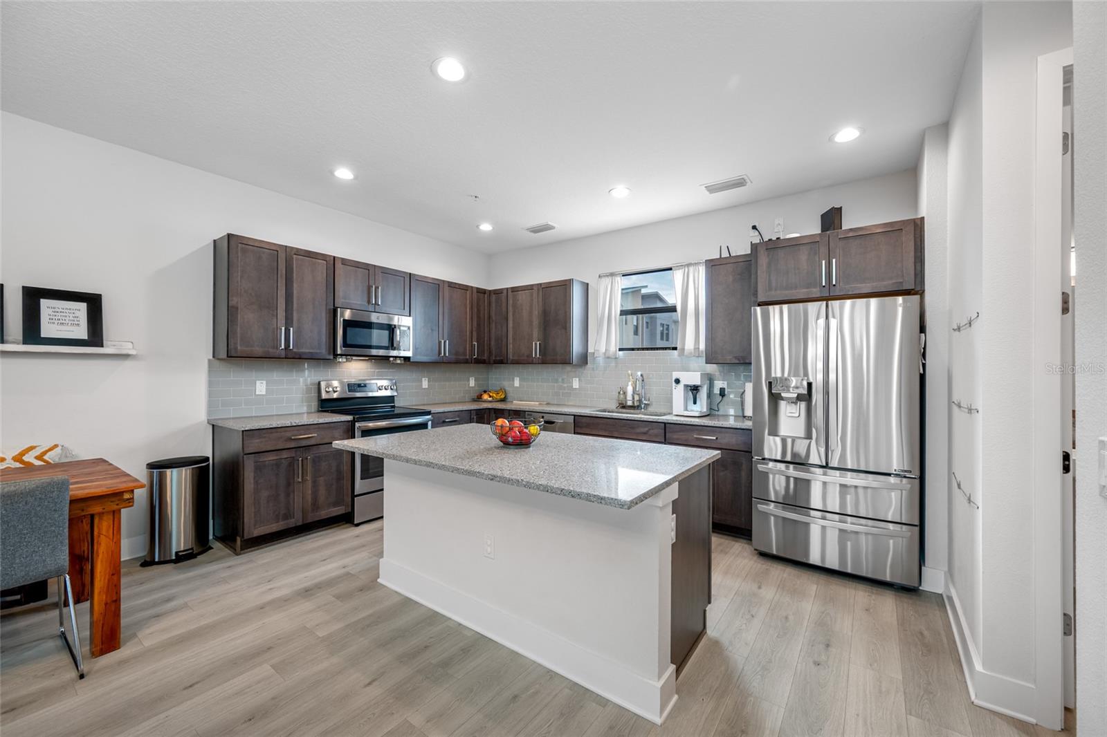 Gourmet kitchen with quartz countertops, Open to the dinning and living room. 10 ft ceilings and oversized windows let in lots of natural light. Second Floor