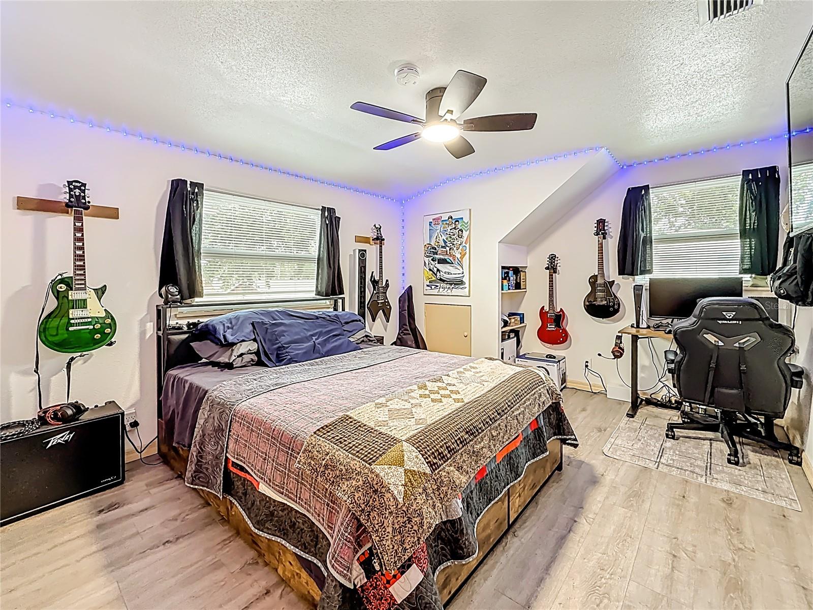 Now you are in the 2nd bedroom upstairs. Behind you is the entrance, over your left shoulder is a wall closet. This room has updated LVP flooring along with LED lights around the ceiling. The window on the left looks out over the front yard. The small door is additional storage.