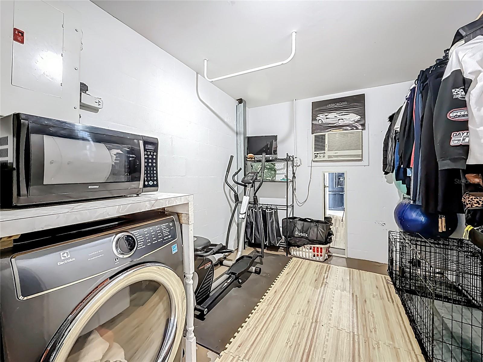 Another view of the flex space within the laundry room in the garage. There are storage cabinets to your right, also ( out of view in this photo). The wall unit makes doing laundry or working out in here to be more comfortable.