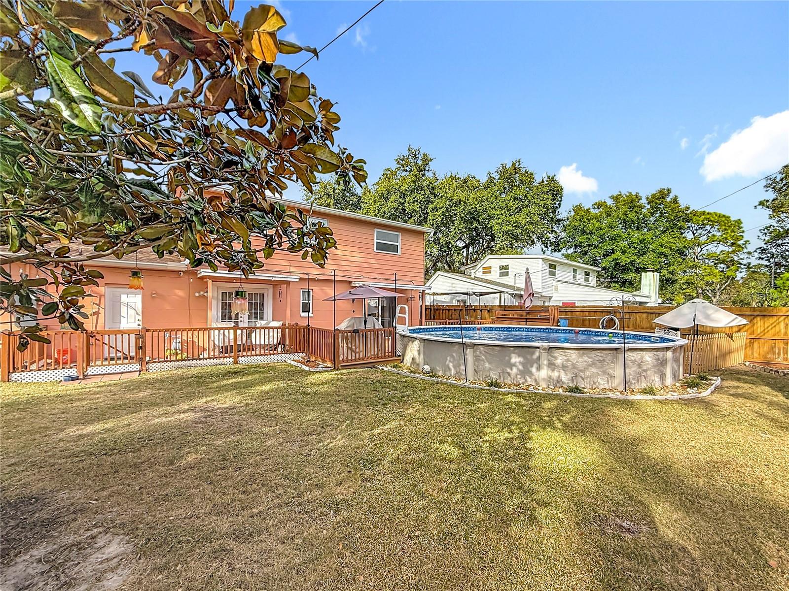 Another view of the large yard. The shower next to the garage door ( left side) is visible in this view.