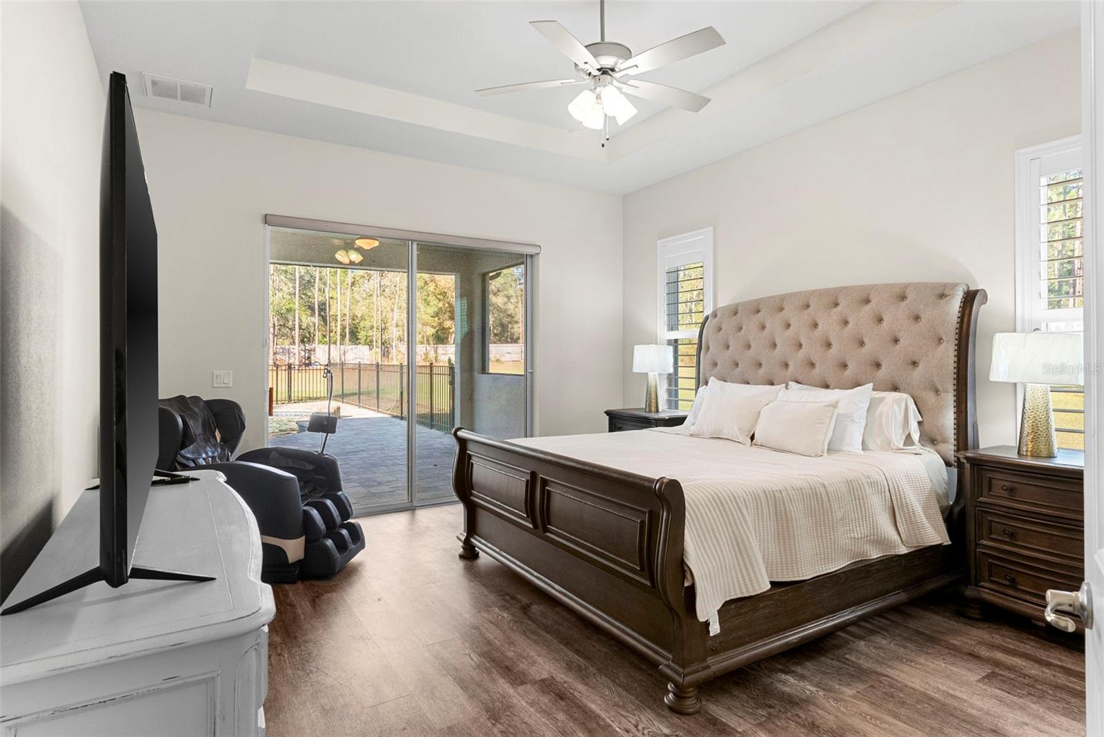 Primary Bedroom** – A tranquil retreat with tray ceiling, sliding doors to the backyard, and space for a full bedroom suite