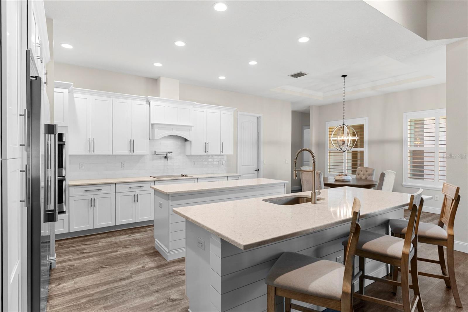 Kitchen Designed for both form and function, this chef's kitchen boasts dual islands, quartz countertops, stainless steel appliances, and sleek shaker cabinetry