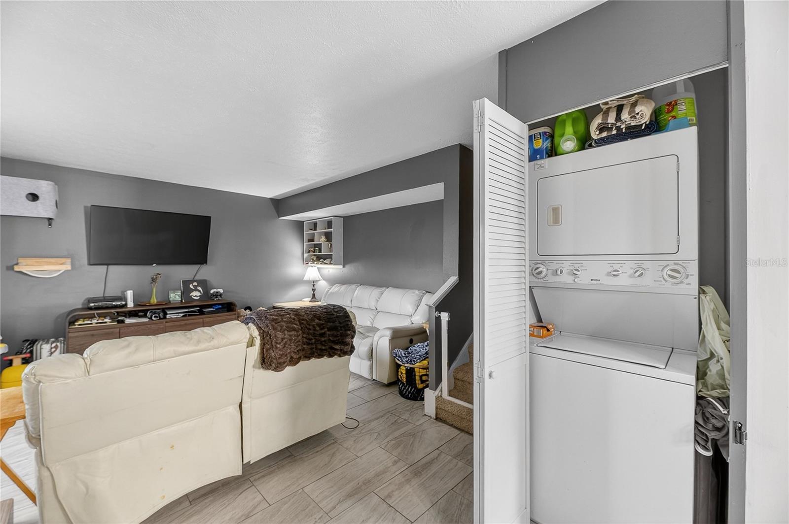 Laundry closet next to stairs