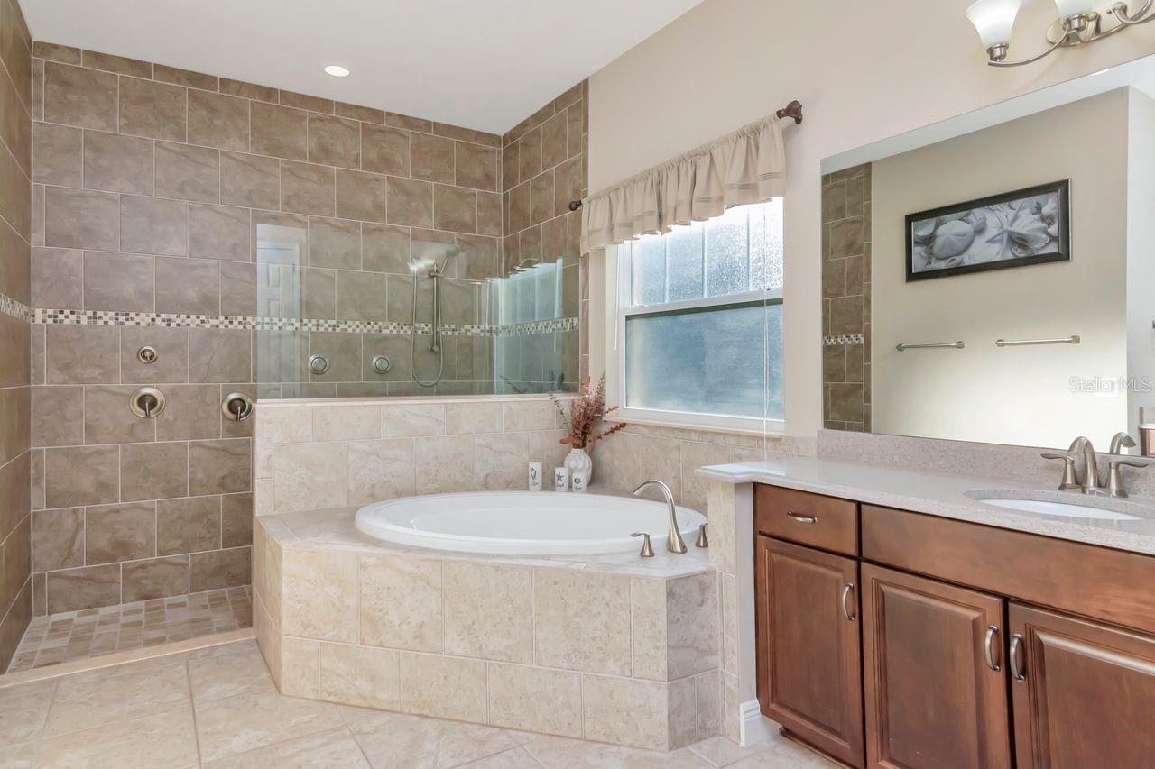 Spa-Inspired Owner’s Bathroom with Garden Tub and Large Frameless Walk-In Shower