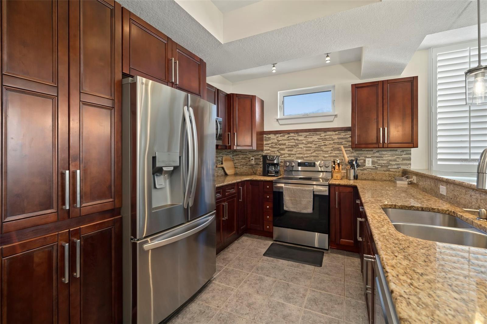 Kitchen with wood cabinets, granite counters, 1 year old dishwasher and range, Refrigerator and microwave are brand new.