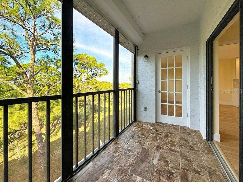 Screened lanai has slate tile and hurricane shutter.