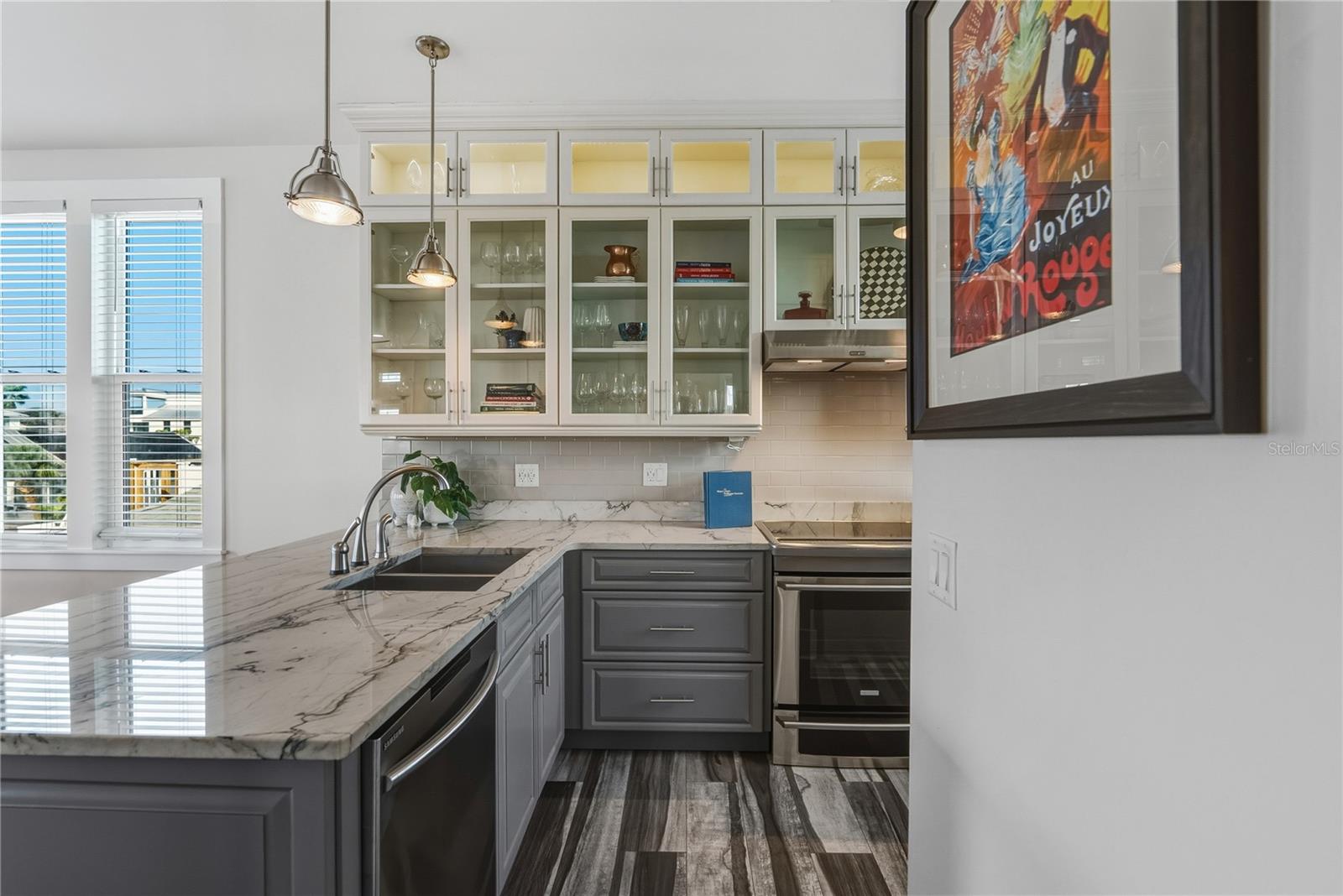 Chef’s kitchen with marble counters + custom cabinetry.