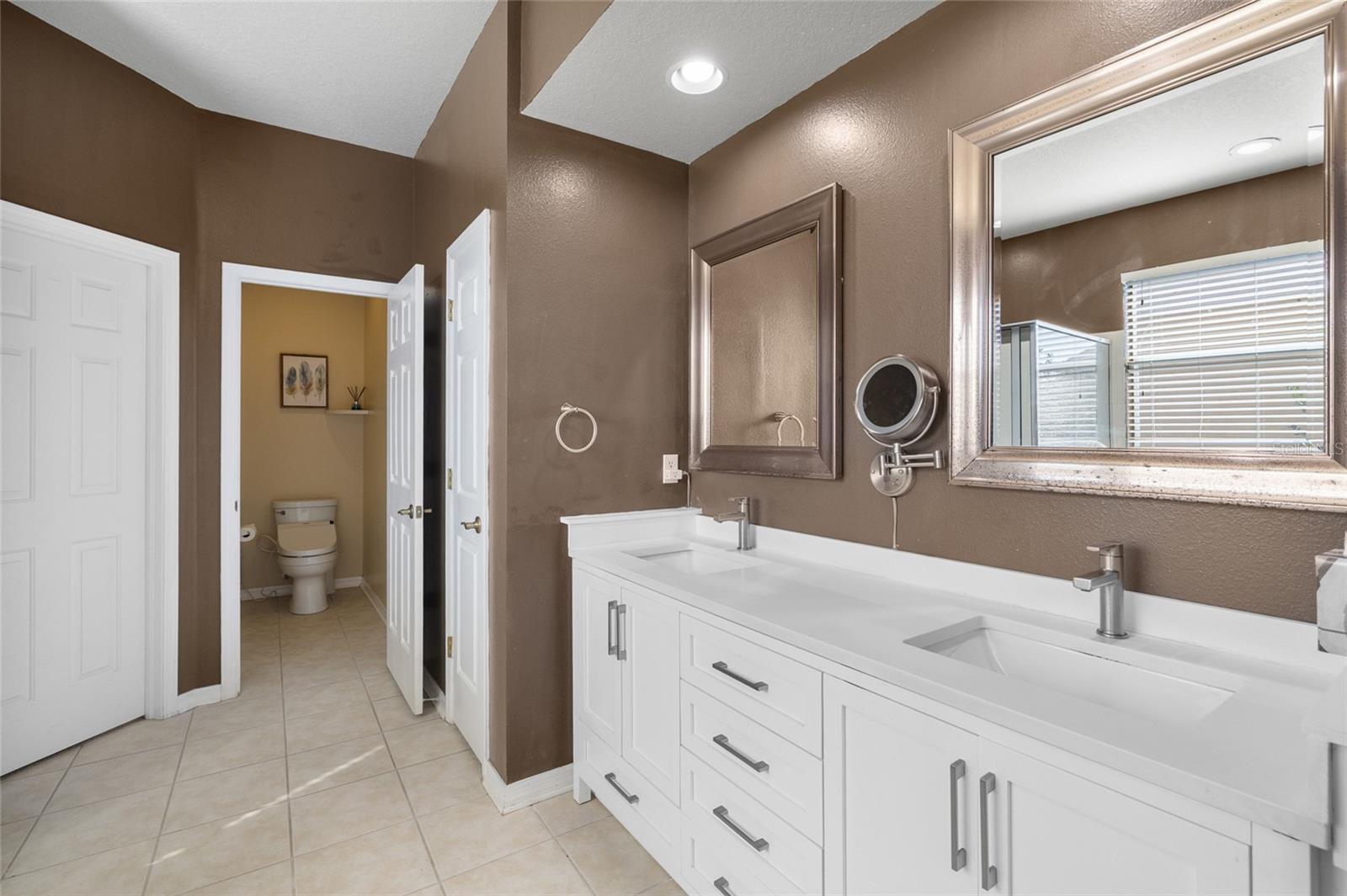 Ensuite bathroom with double sinks, soaking tub, separate shower stall and walk-in closet