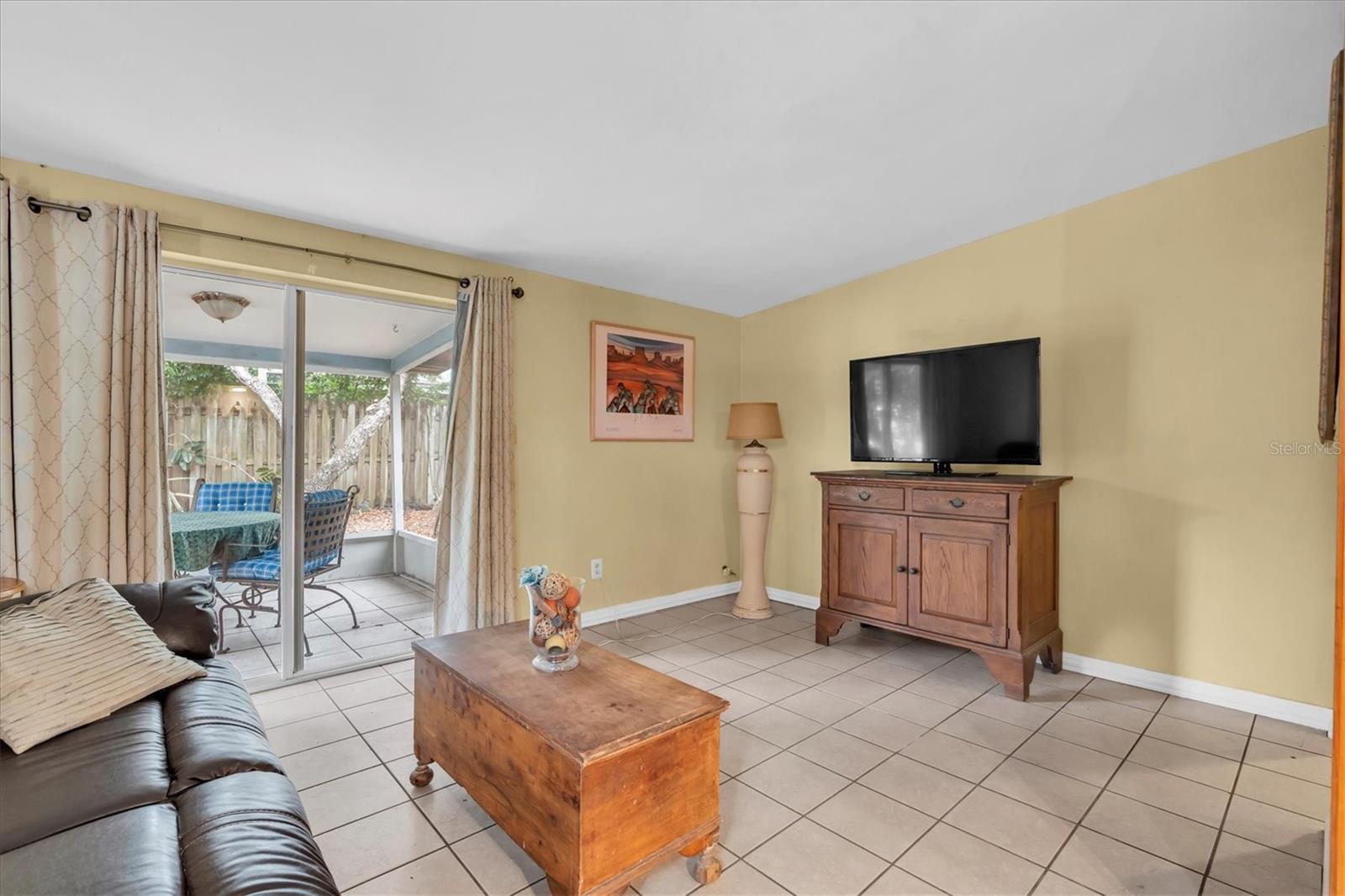 Living rooom with a entrance into the screened in porch.