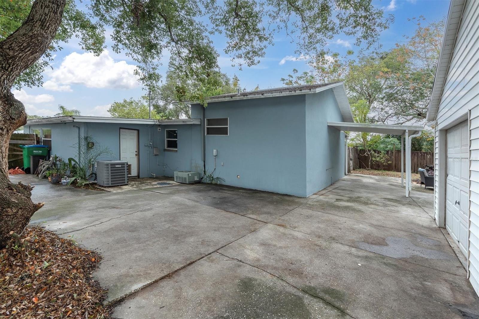 Side view of the back yard garage area, parking and covered porch.