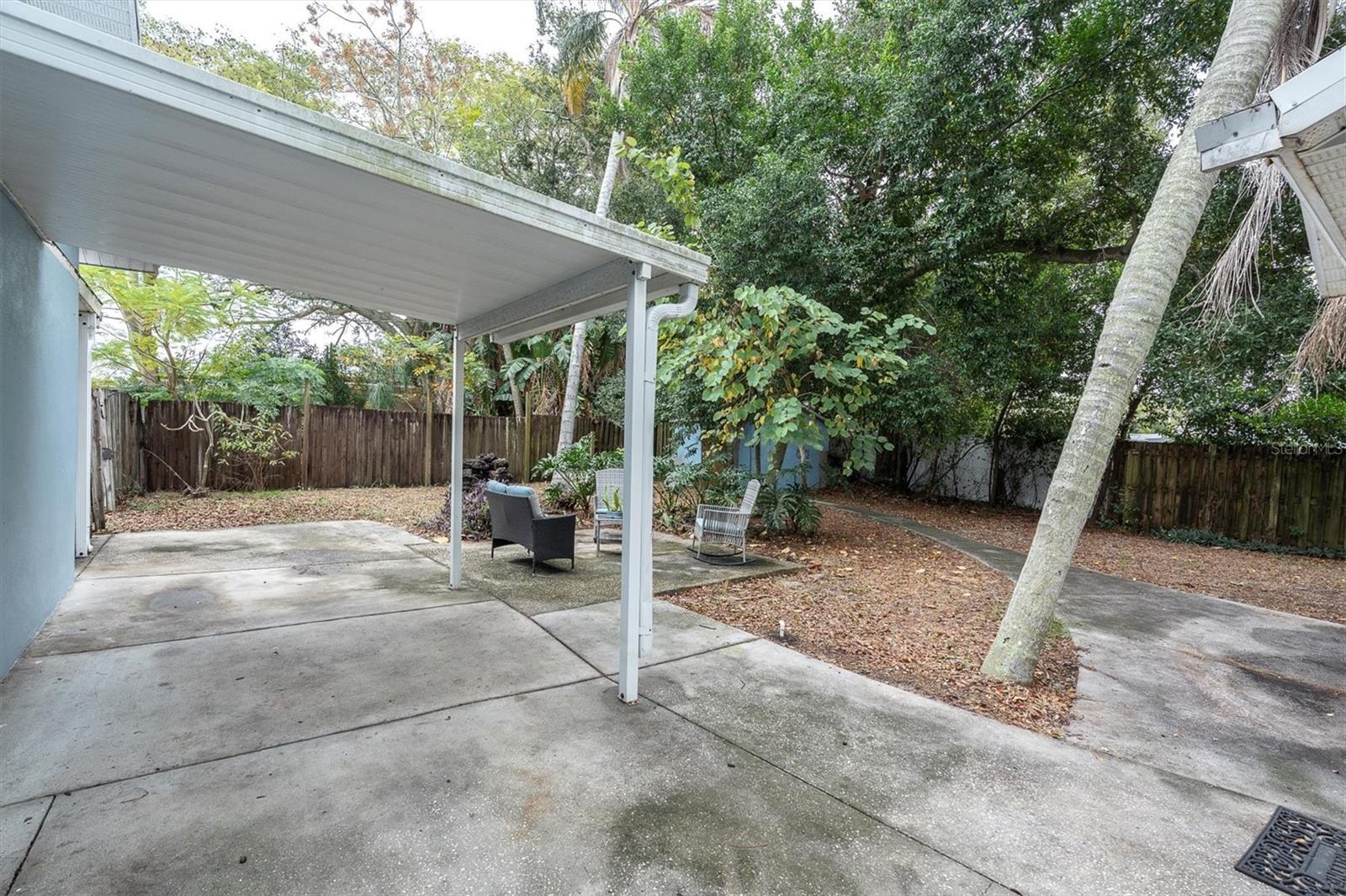 Large back yard with a covered porch area.