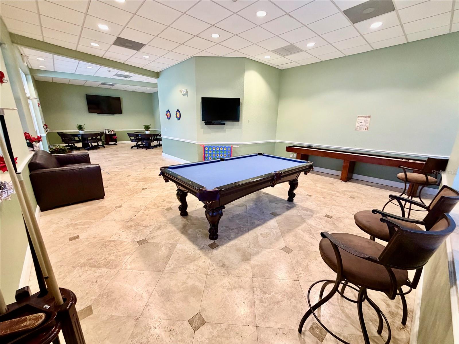 Spacious community lounge with pool table and gathering space.