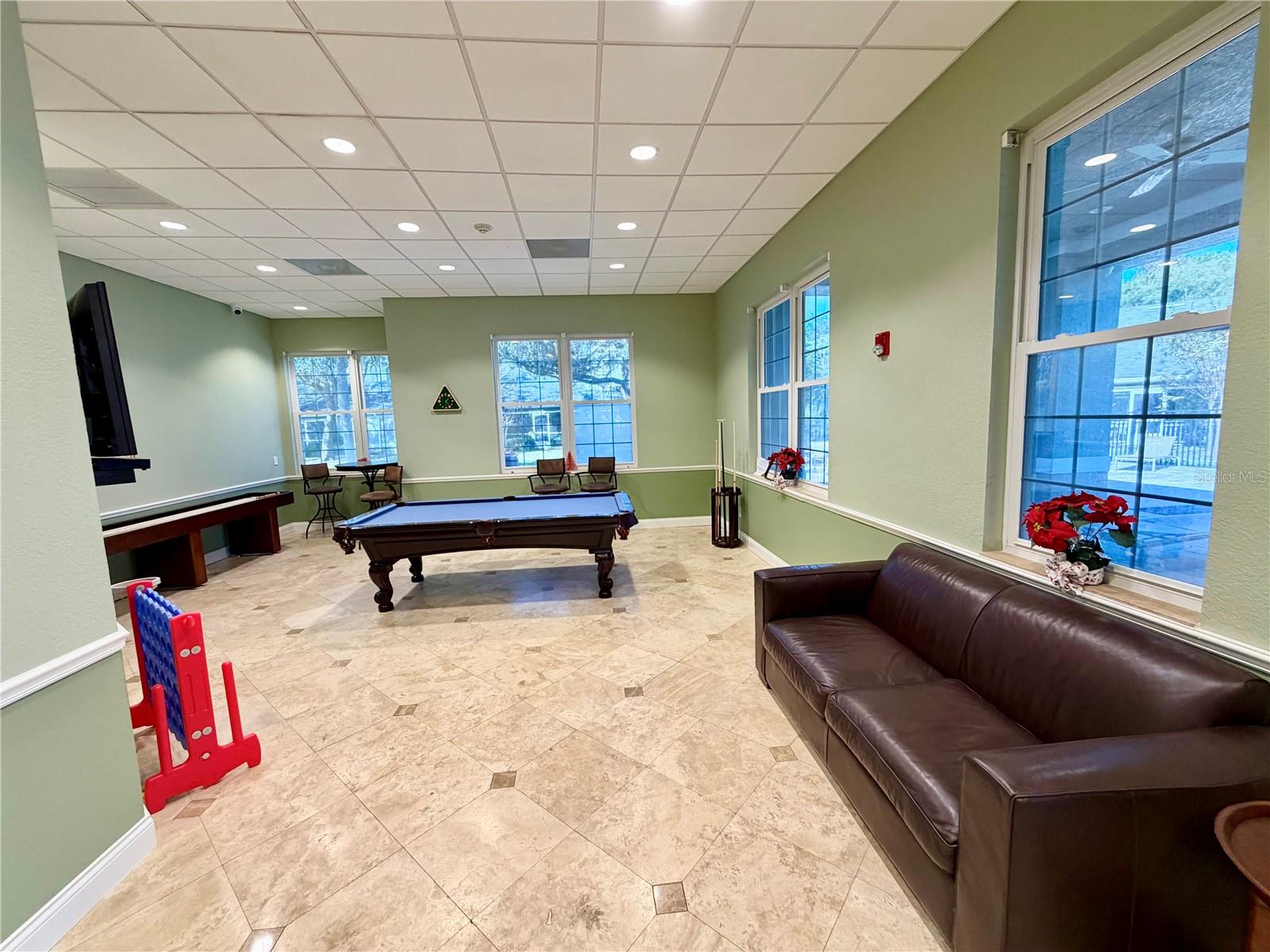 Spacious community lounge with pool table and gathering space.