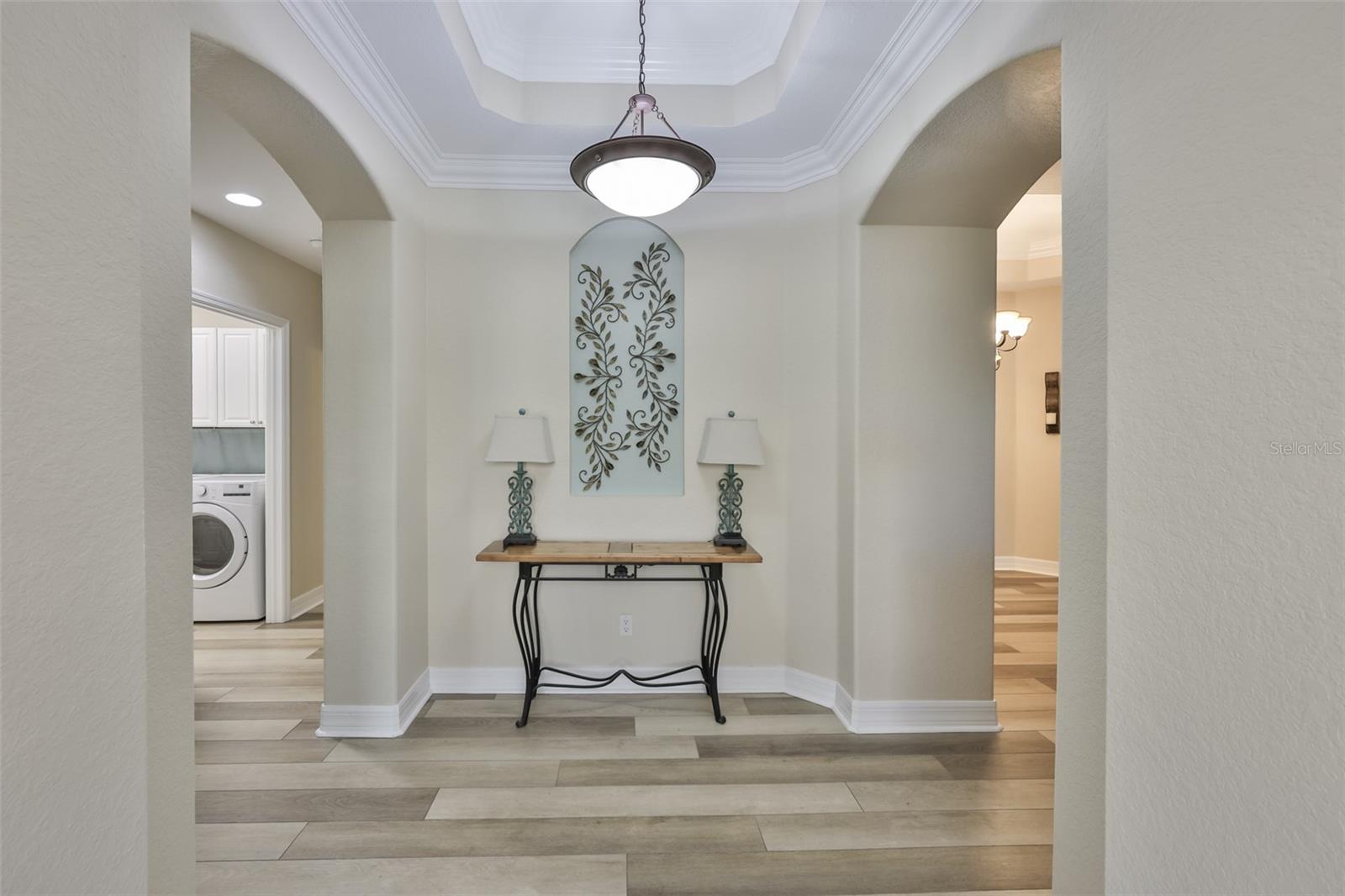 As you walk into the condo, a formal entrance welcomes you and your guests.  Trey ceiling and crown molding are just a few of the high end features of this home.  Bedroom 2 & 3, laundry room and guest bath are to your left, with the rest of the living area to your right.