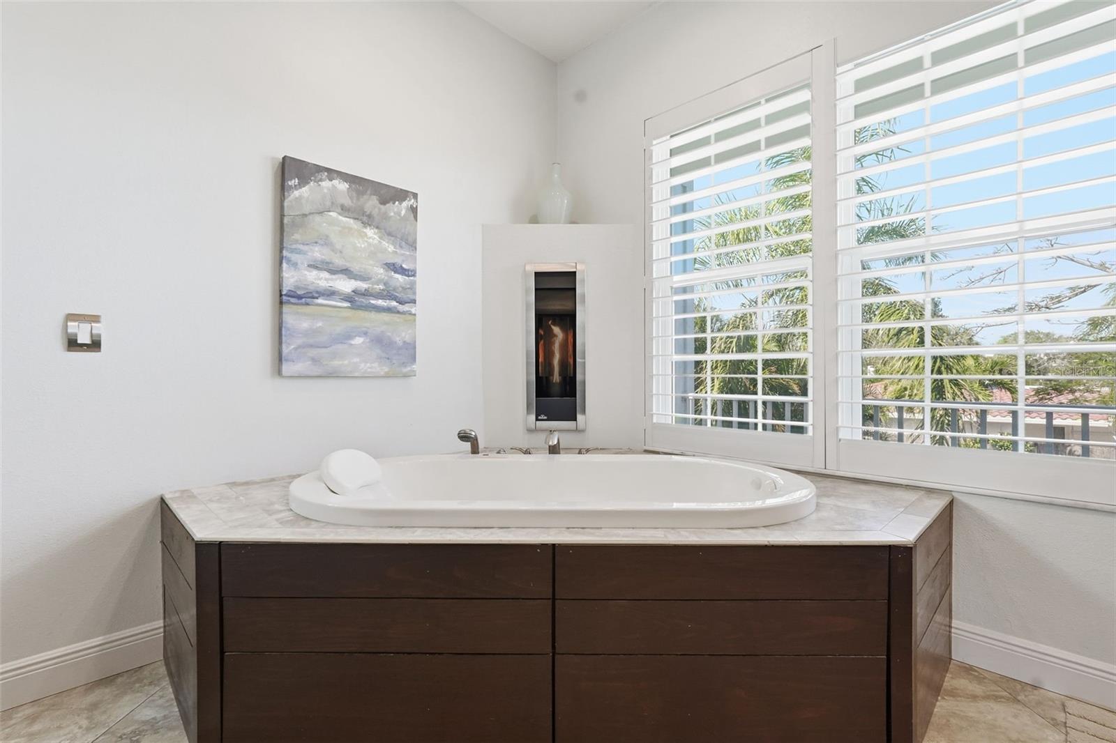 Master bathroom, fireplace on the wall.