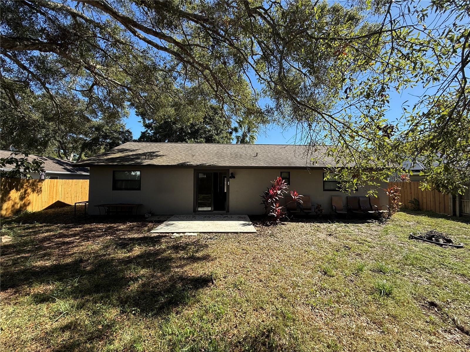 Exterior back with concrete patio and sliders going inside.