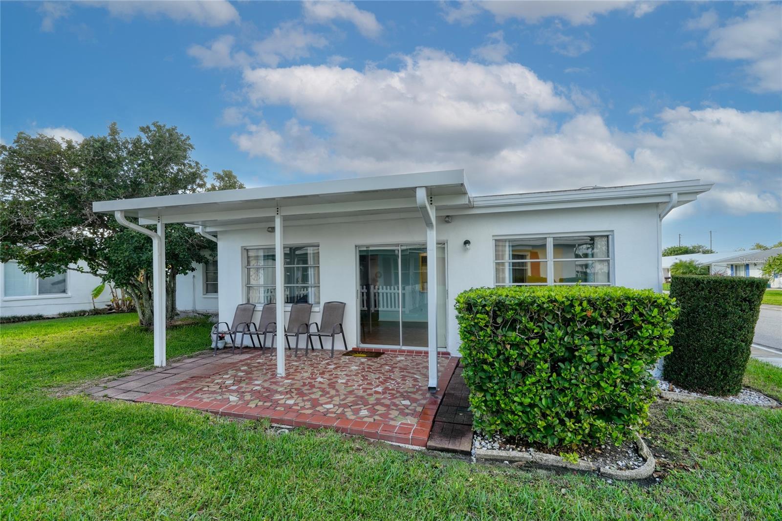 The covered patio has the same tiles as the front walkway.