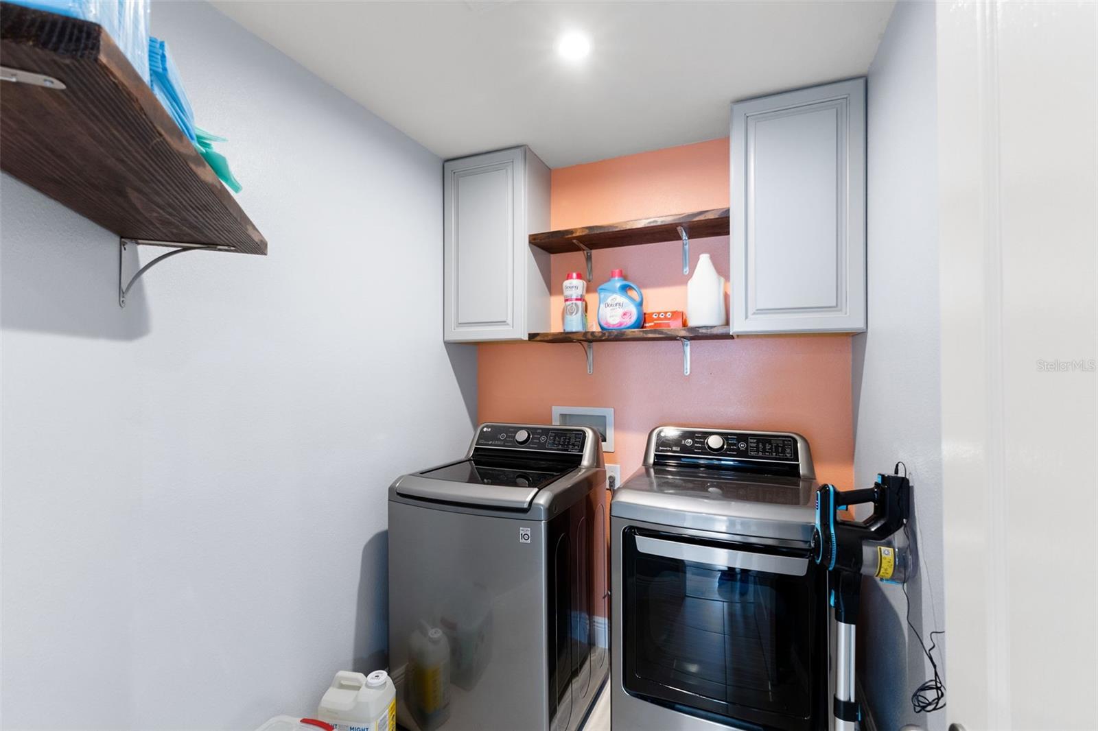 Upstairs laundry room with upper cabinetry storage