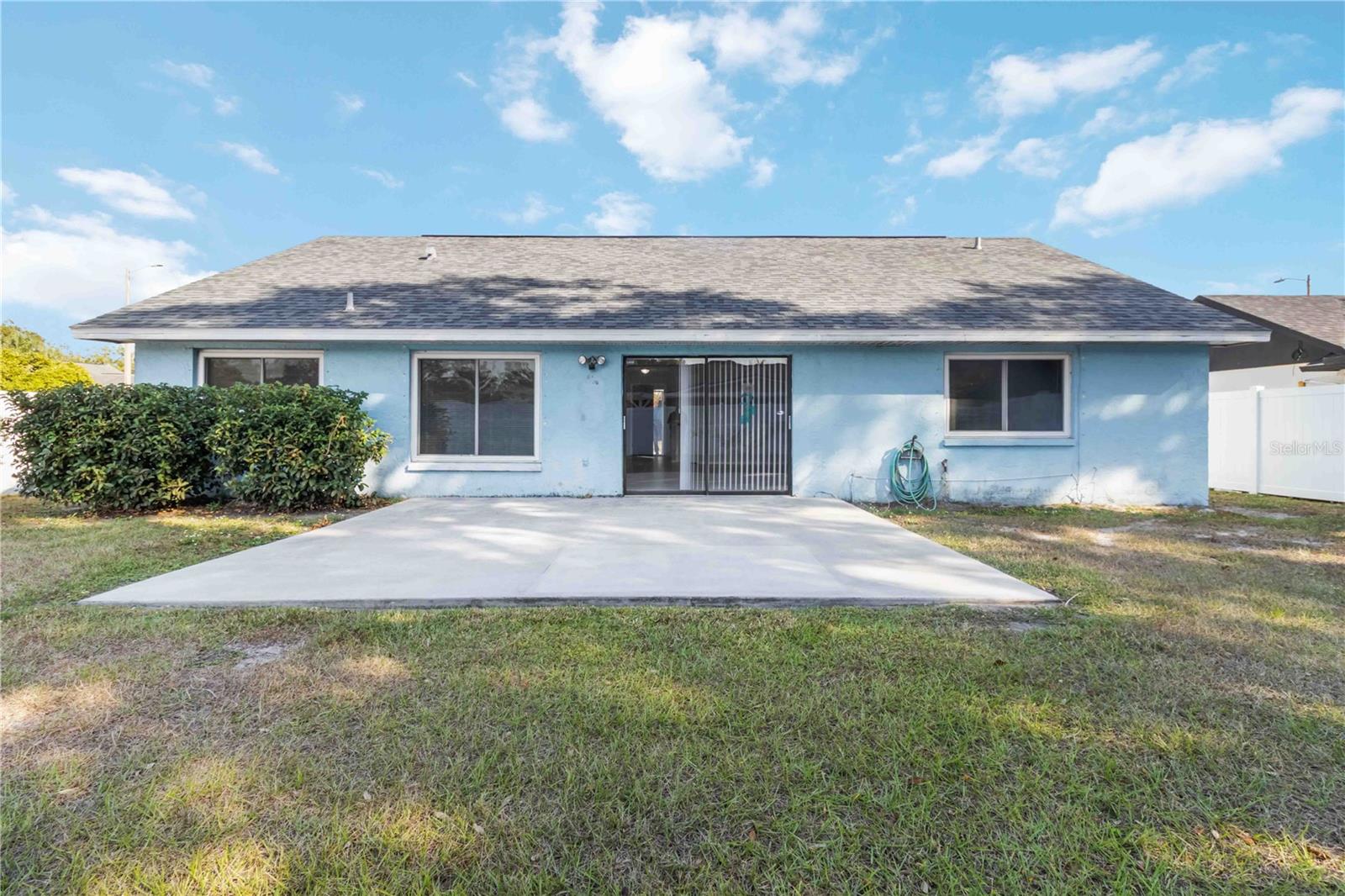 Backyard w/ concrete slab patio.