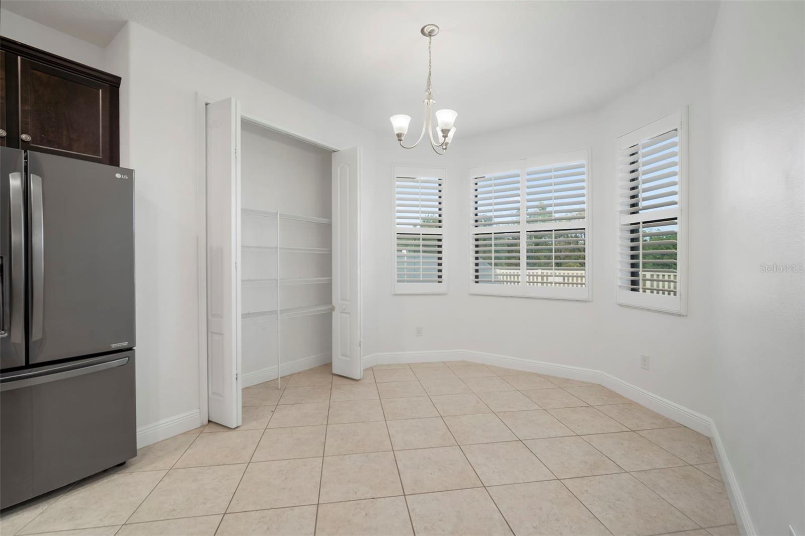 Breakfast area with pantry and windows looking out to a water view in the backyard.