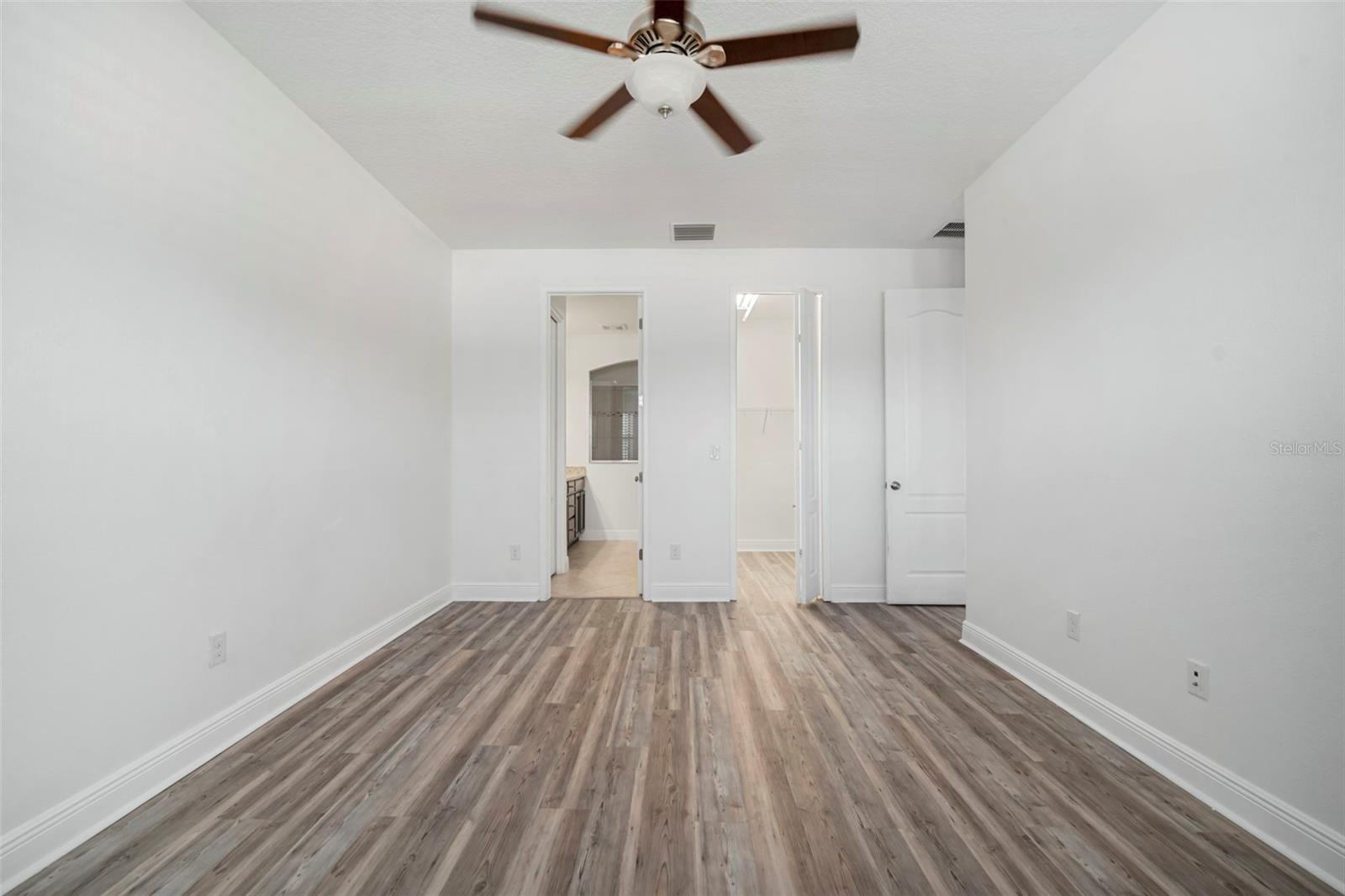 Primary bedroom looking into the primary bath and walk-in closet.