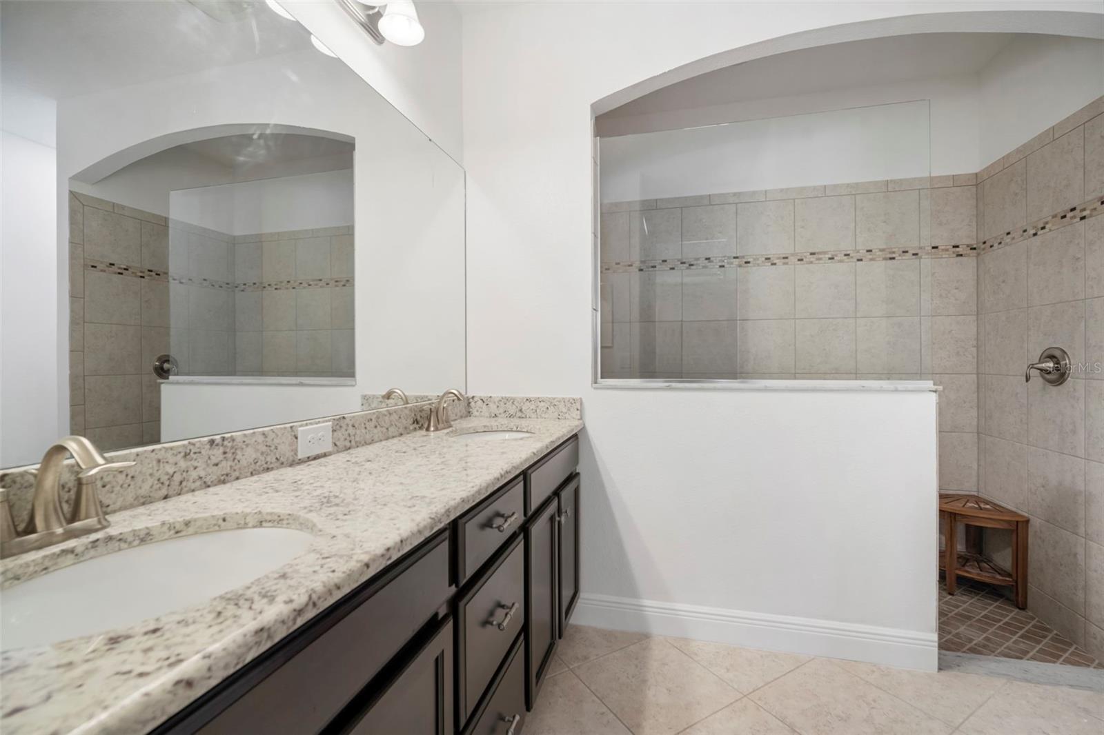 Primary bathroom with double sinks and granite counters.
